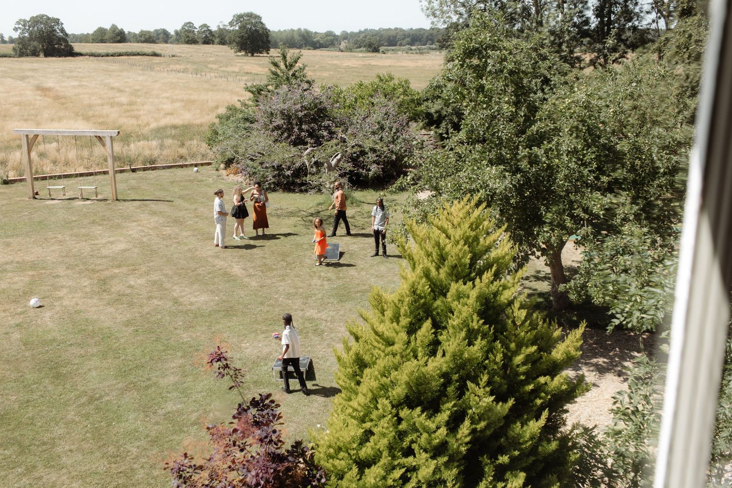 Scenic view of a grassy field with trees and people visible in the distance.