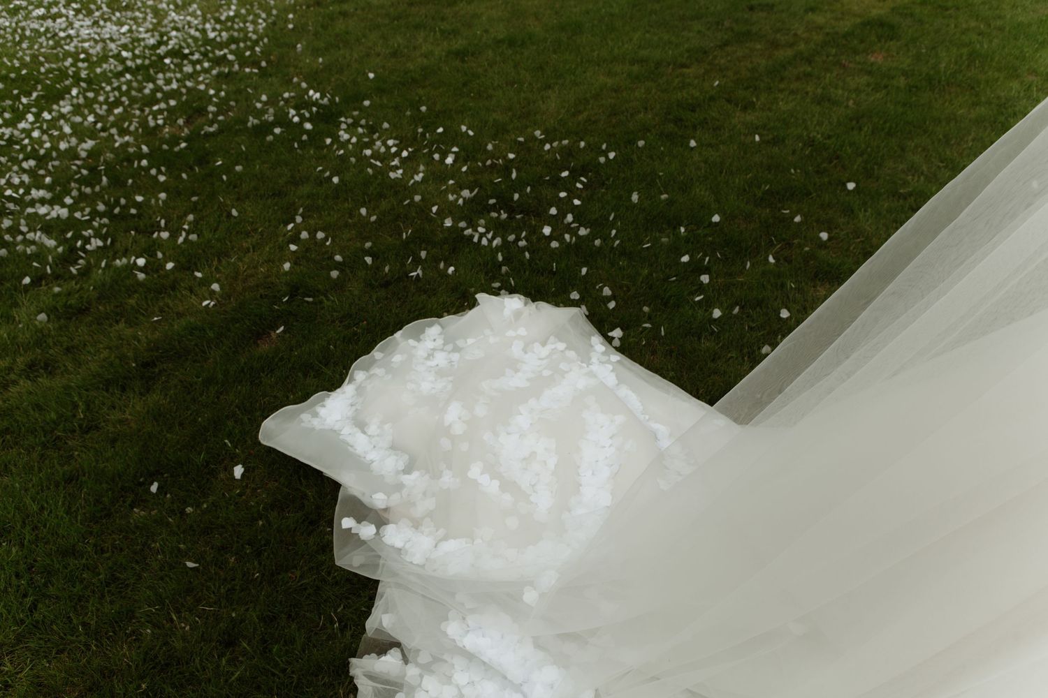 A cascading collection of wedding candid photos showing white dress details against a dark background.
