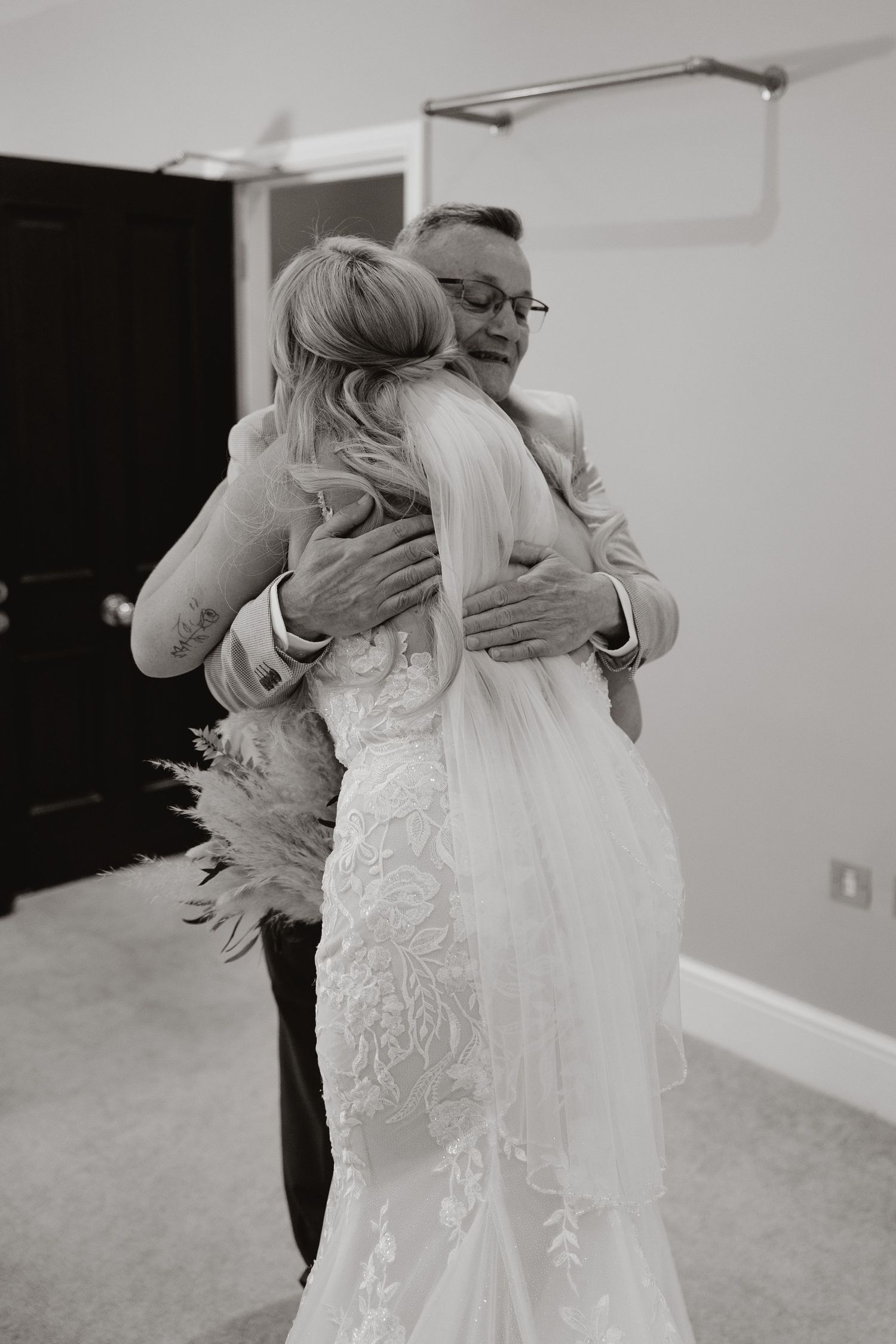 Monochrome sequence of a bride in a white lace gown sharing an intimate first look moment.