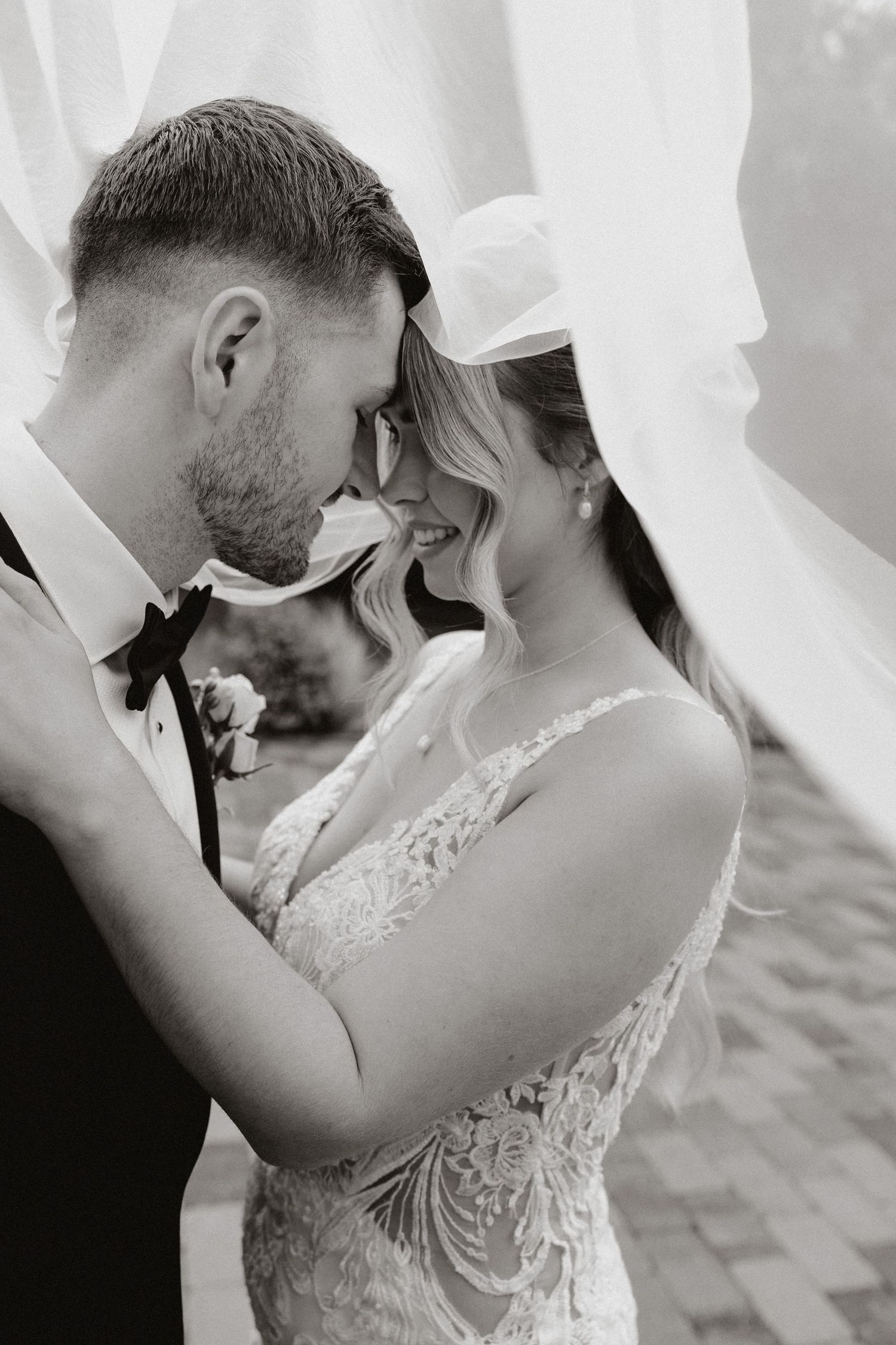 A romantic black and white photo series showing intimate wedding moments between a couple in formal attire.