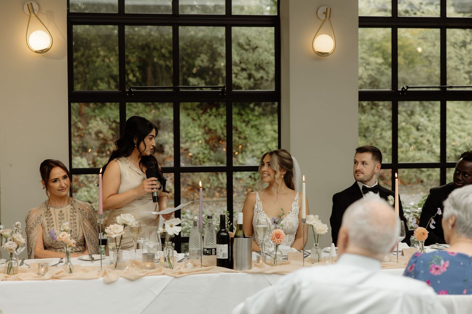 A sequence of candid wedding reception moments showing guests dining and socializing at tables in an elegant venue.