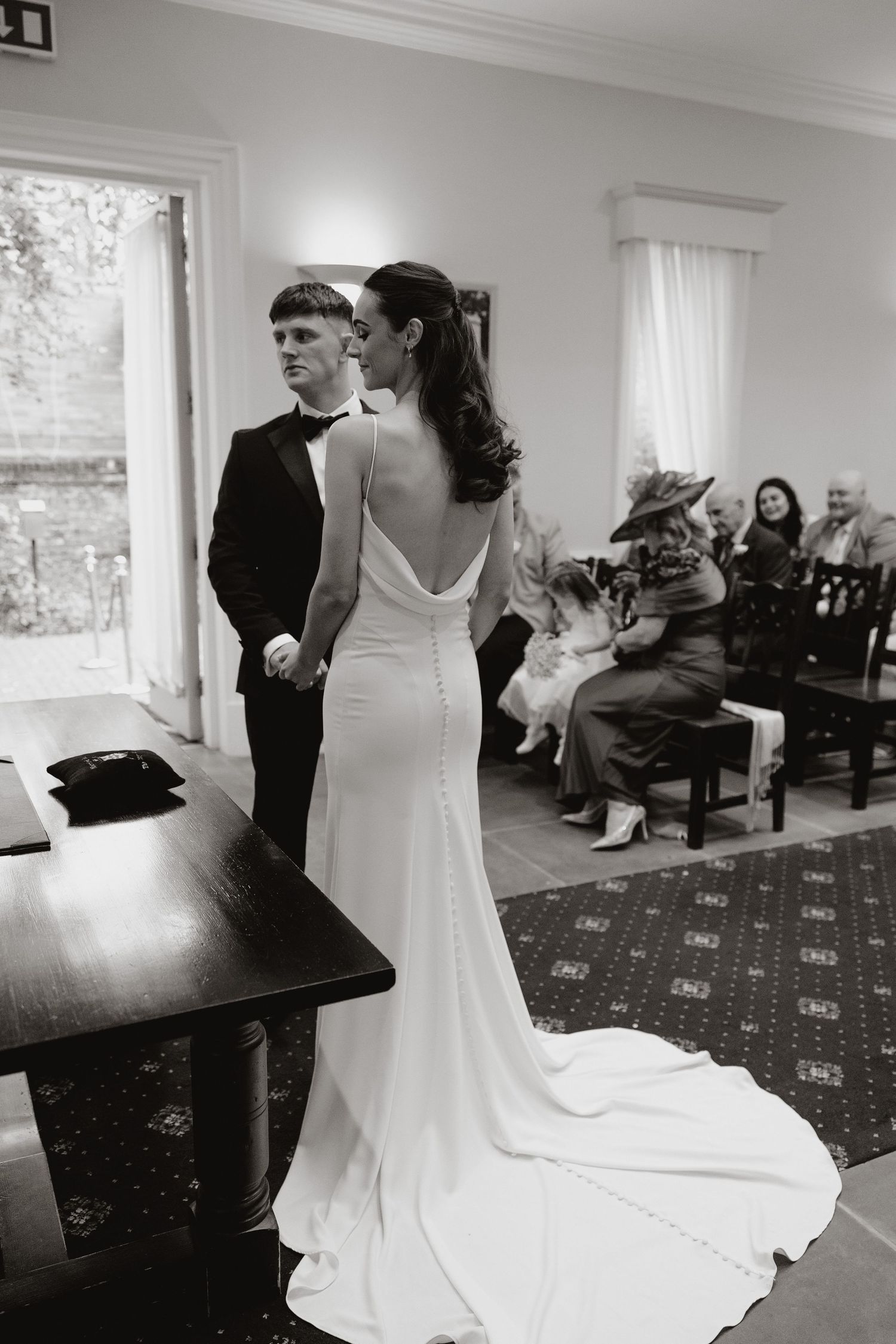 A sequence of black and white wedding photos showing a couple during their first dance in an elegant reception hall.