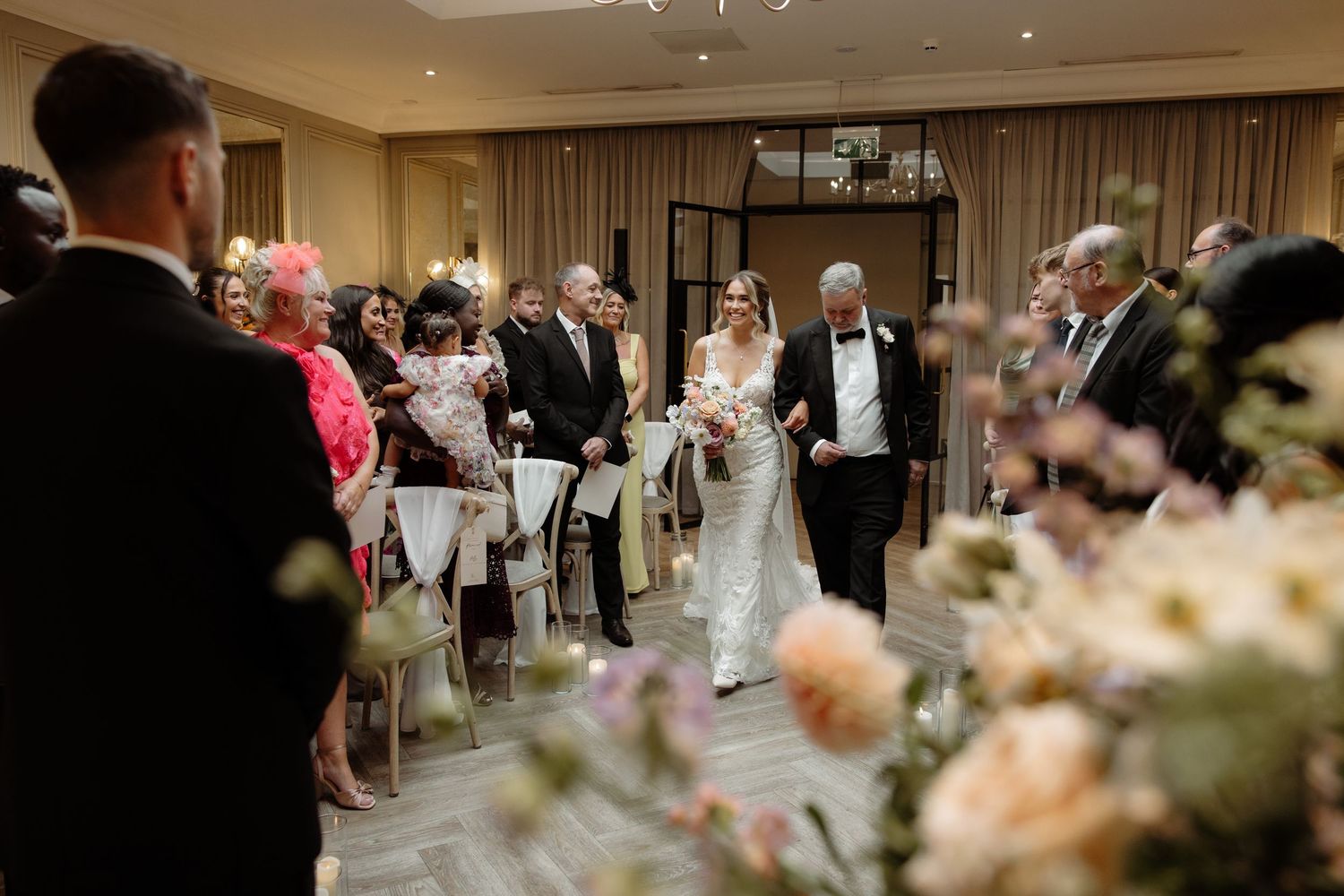 A wedding reception dance floor filled with guests celebrating and dancing together under warm indoor lighting.