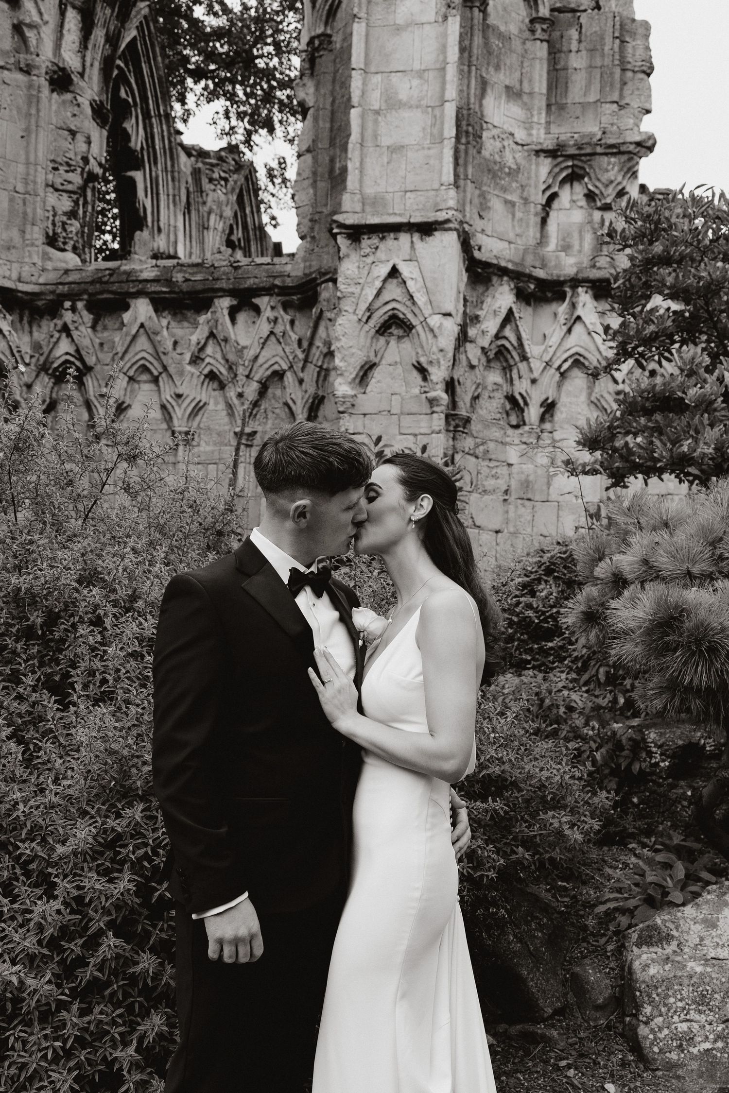 Black and white romantic sequence showing a couple embracing near gothic cathedral ruins.