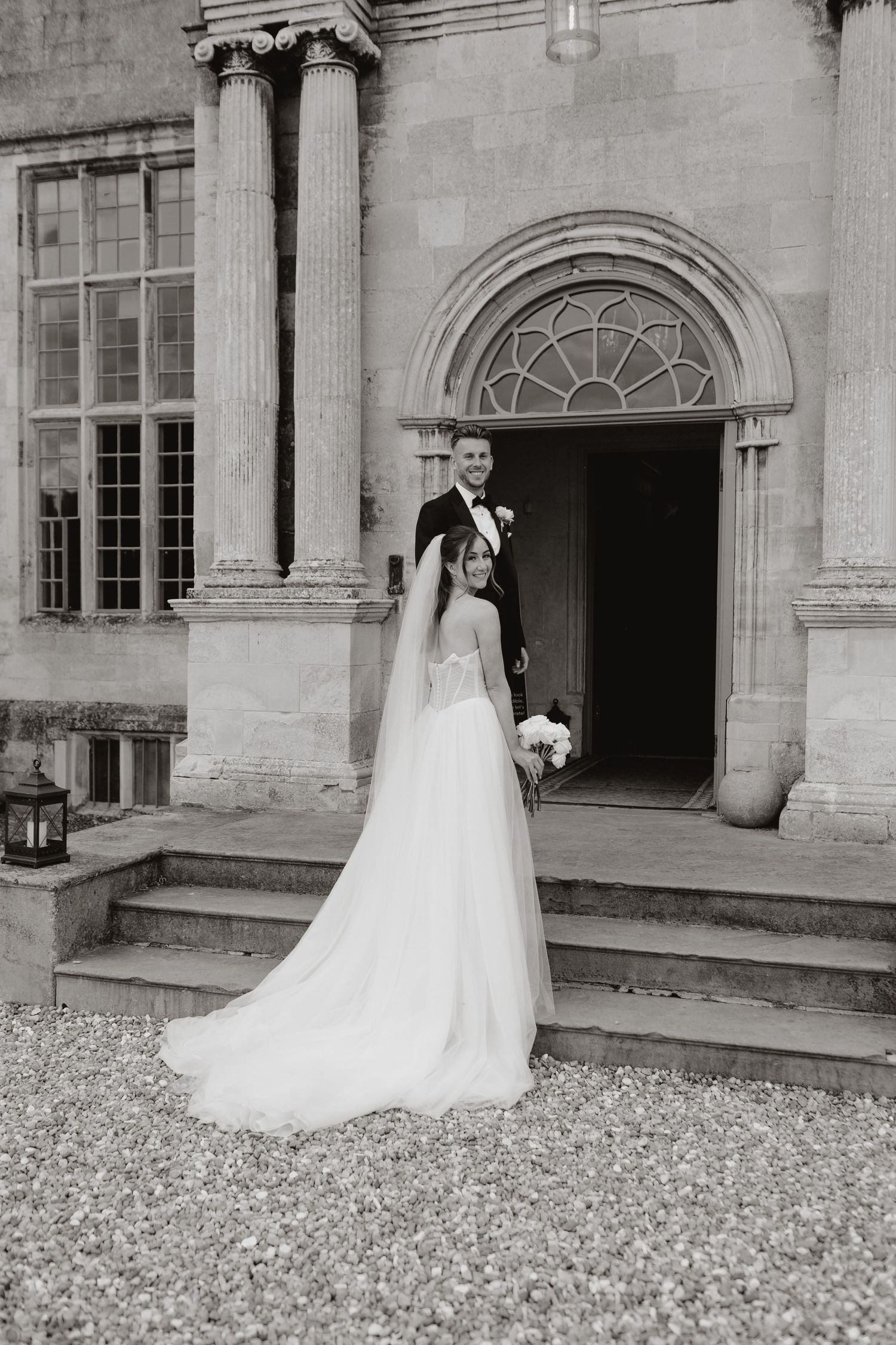 A series of black and white wedding photos showing a bride in a flowing white dress with long train at a historic building entrance.