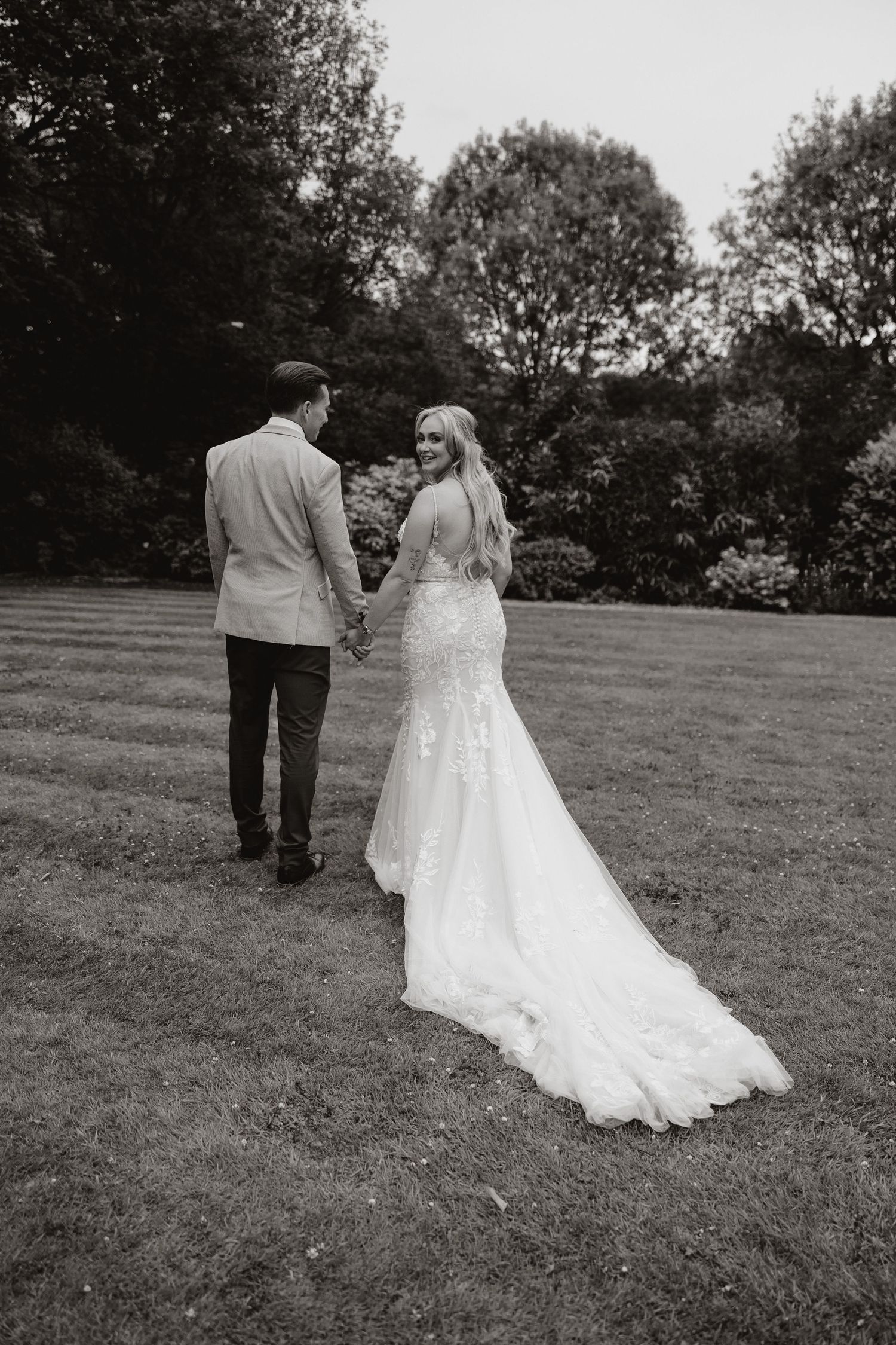 A black and white photo sequence shows a couple walking together on a grassy hillside during their wedding day.