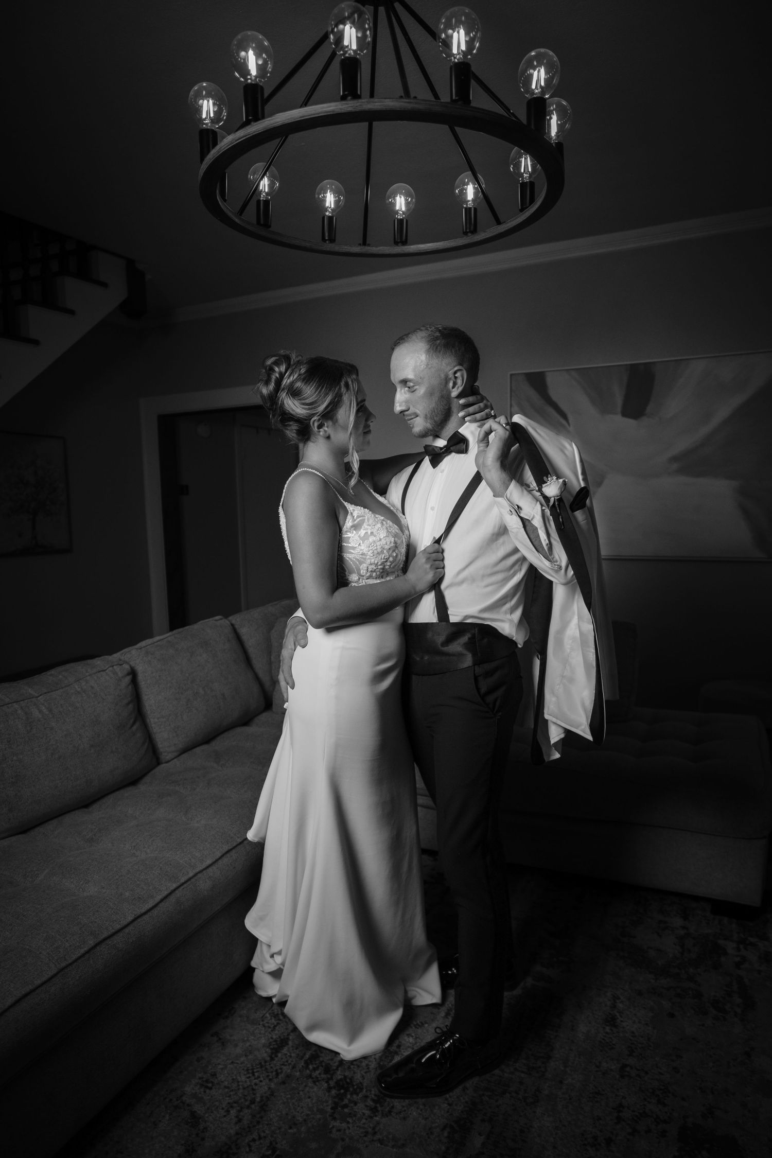 A romantic wedding dance dip sequence in dramatic black and white lighting under an elegant chandelier.