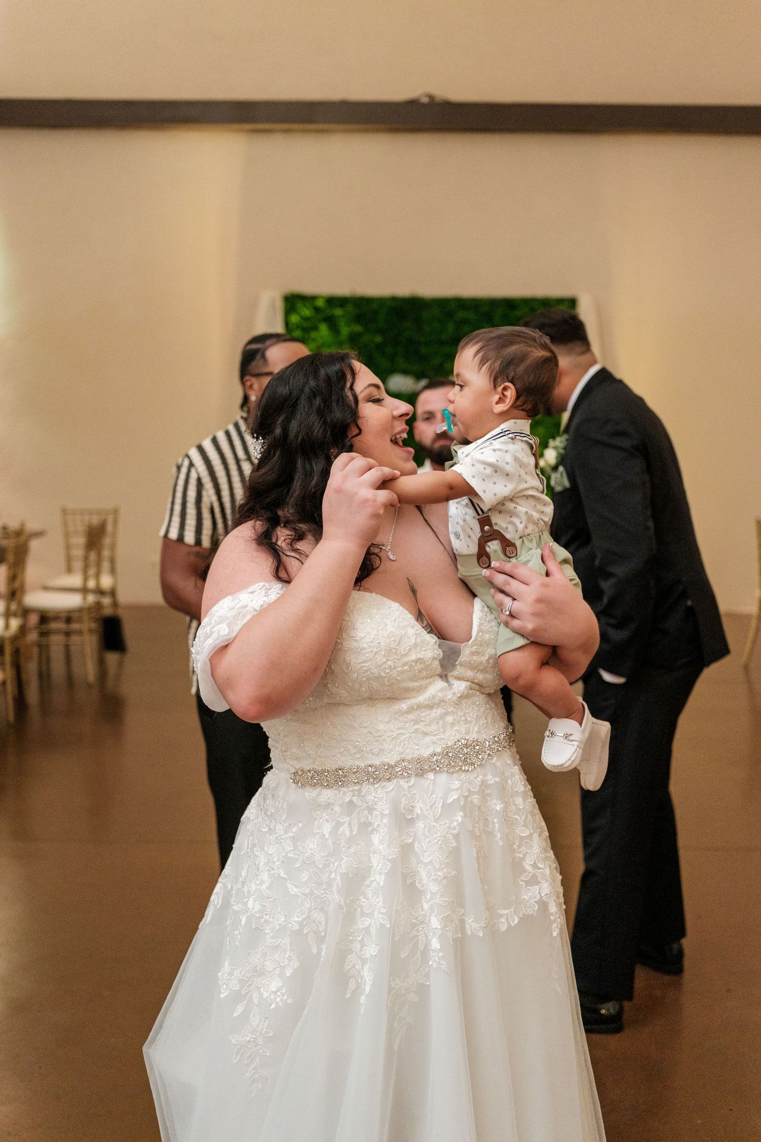 A tender wedding moment captured as a couple in formal attire shares their first kiss.