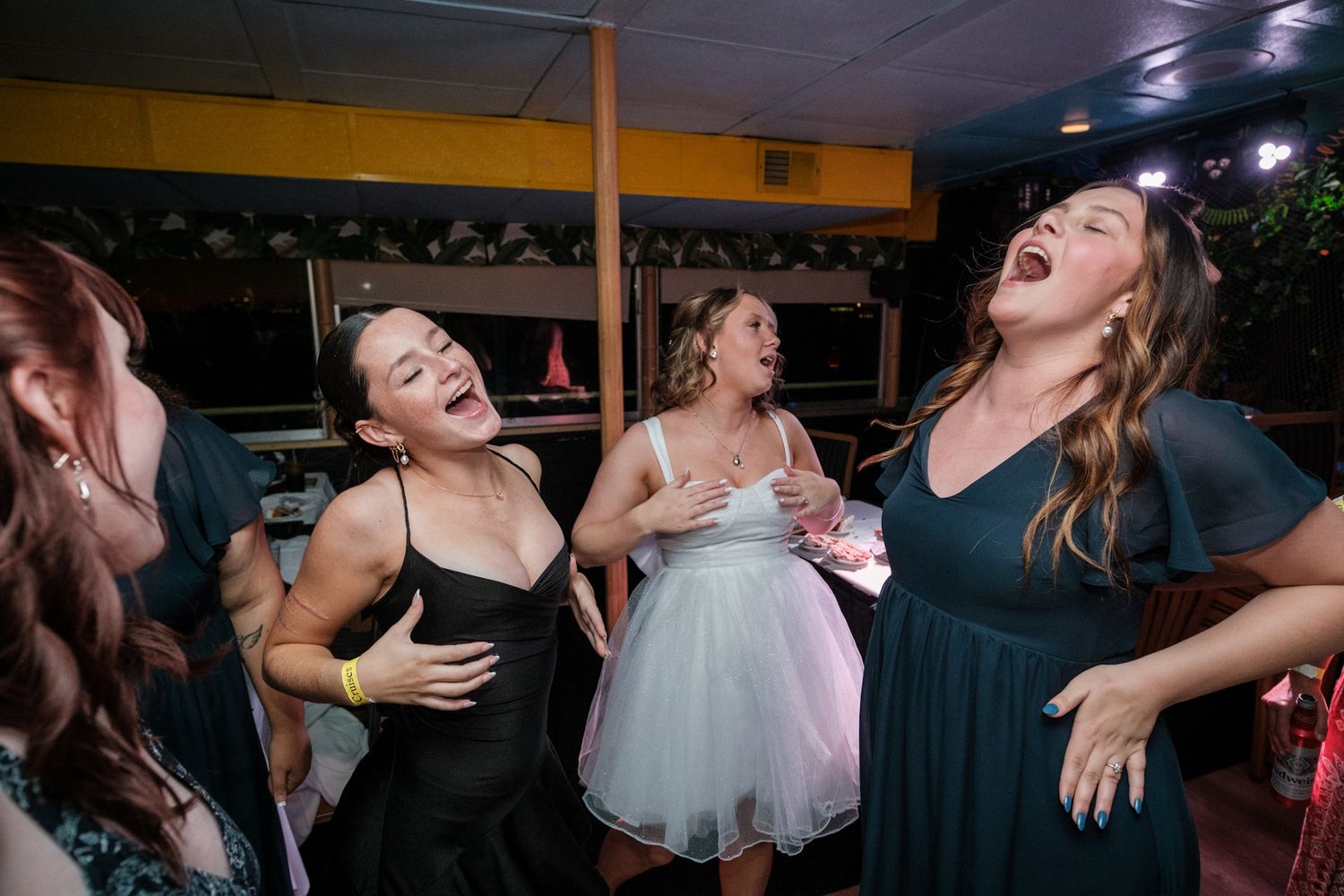 Energetic wedding guests dancing and celebrating together on the dance floor at a reception.
