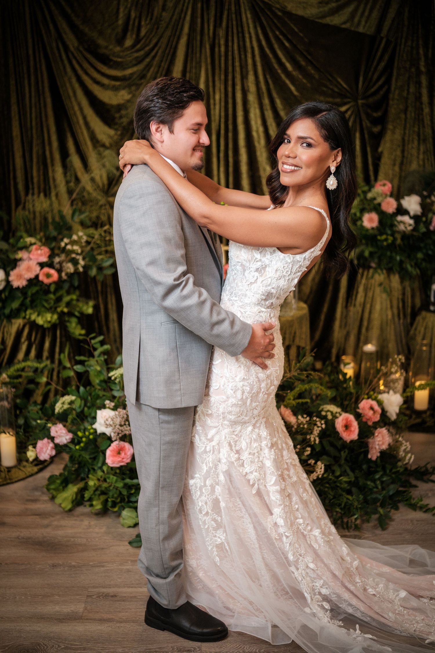 Romantic dance sequence against gold curtain backdrop with pink floral decorations.