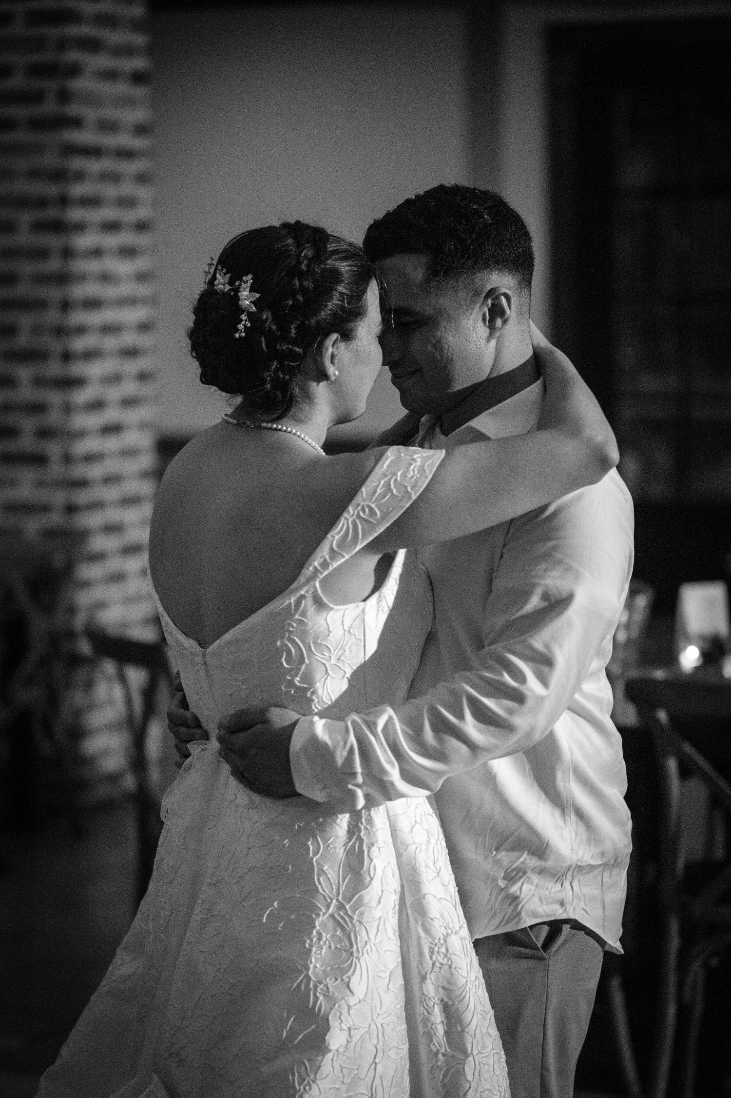 Bride and groom share an intimate first dance in black and white wedding photo.
