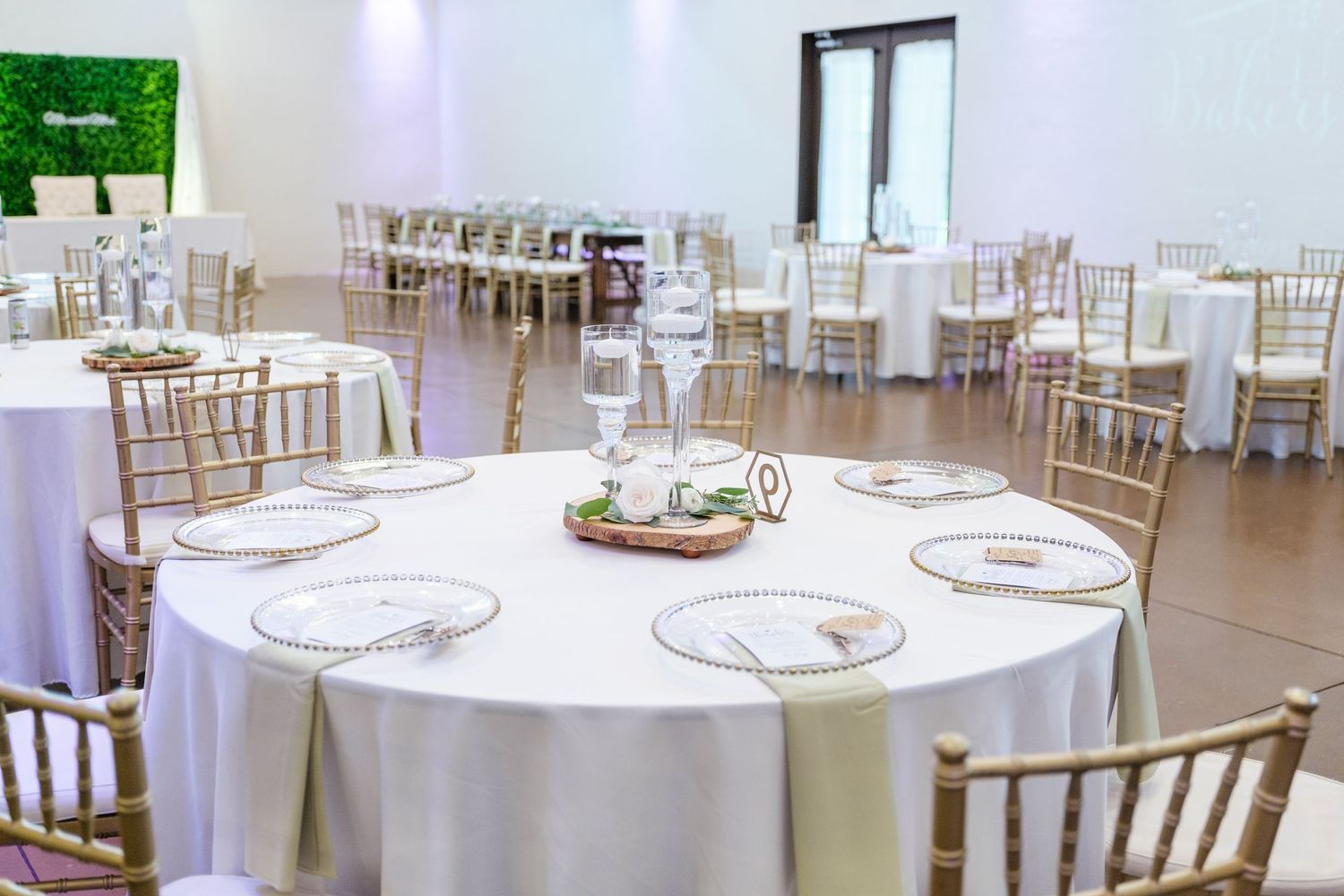 White round tables with gold chiavari chairs set up in an elegant banquet hall for a formal event.