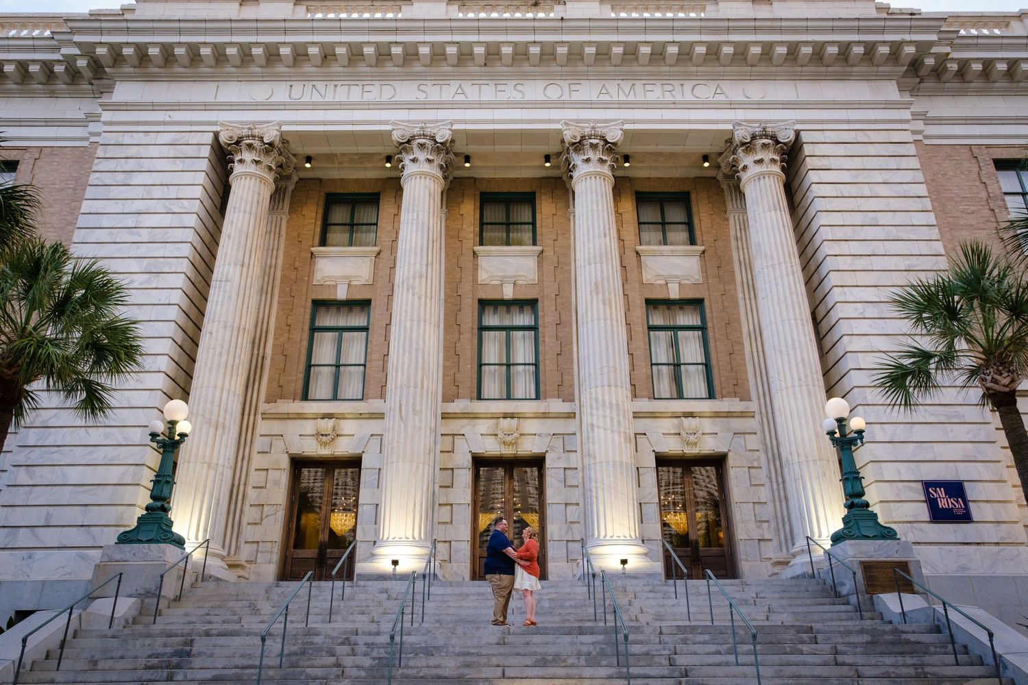 Exterior view of a grand neoclassical building with white columns and ornate architectural details in daylight.