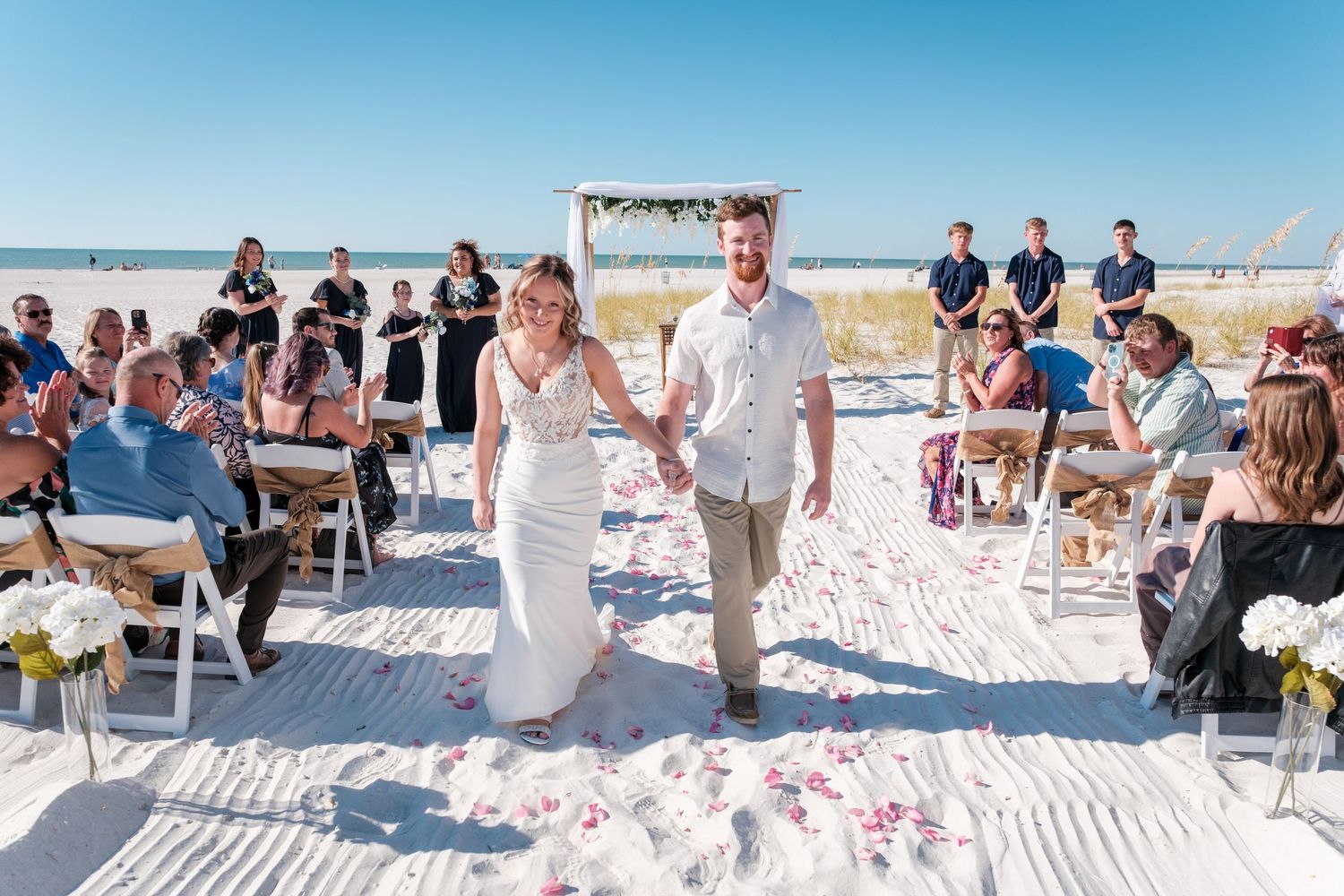 A collage of beach wedding moments showing guests and celebrations on white sand under bright blue skies.