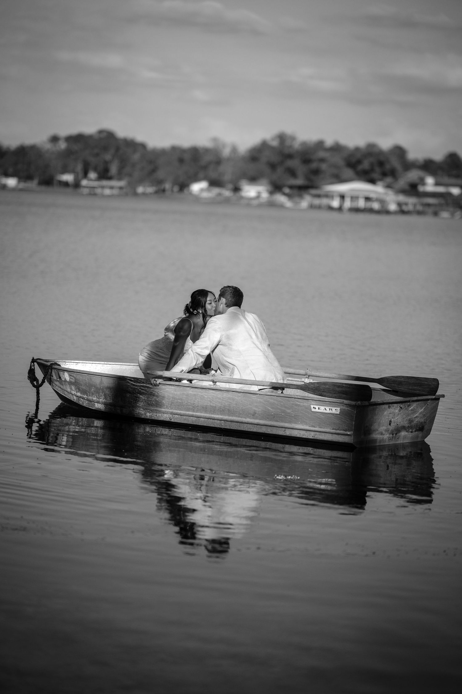 A romantic black and white photo sequence shows a couple kissing in a small boat drifting on calm waters.