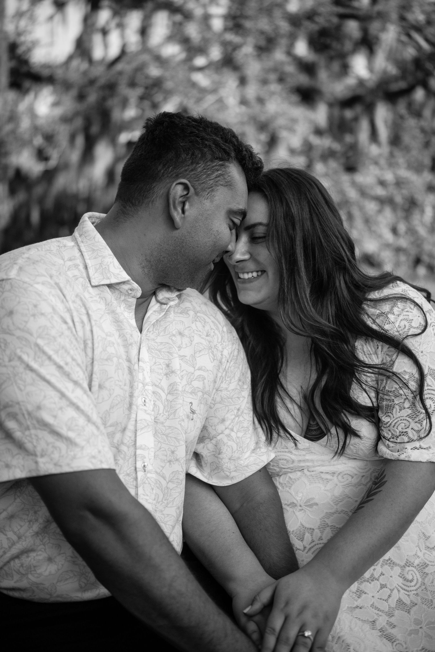 A romantic black and white photo series showing a couple embracing and sharing intimate moments together outdoors.