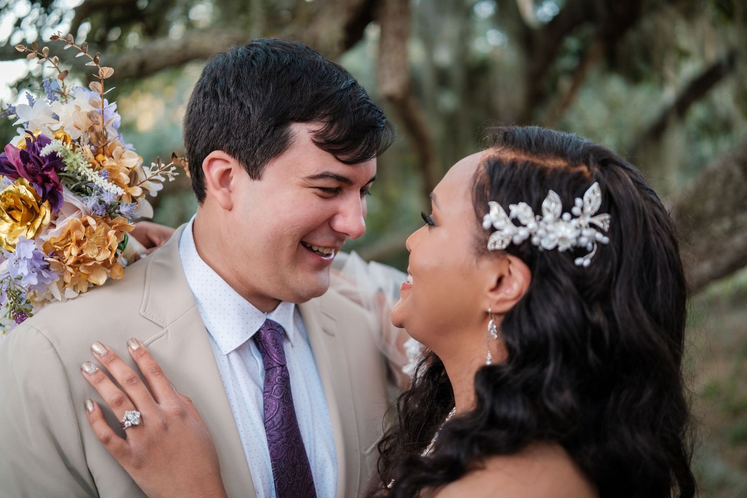 A couple shares a romantic moment outdoors during their wedding day celebration.