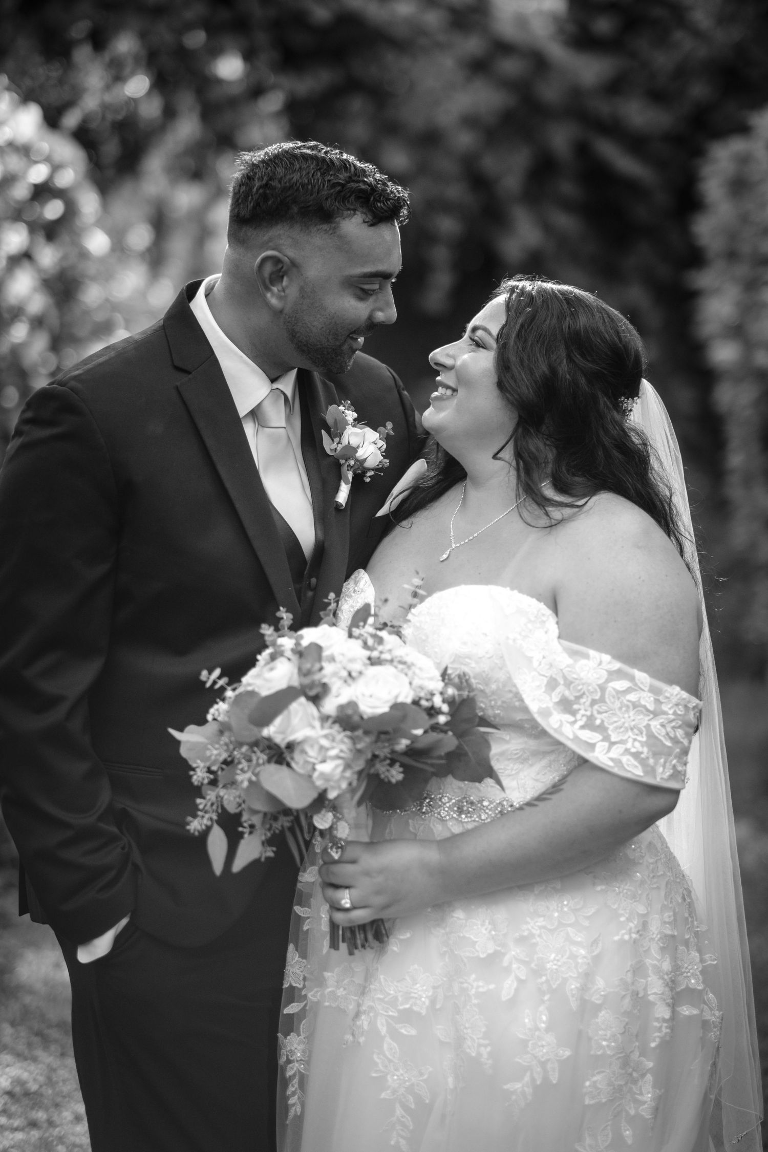 A romantic black and white wedding photo series showing a couple sharing intimate moments in an outdoor setting.
