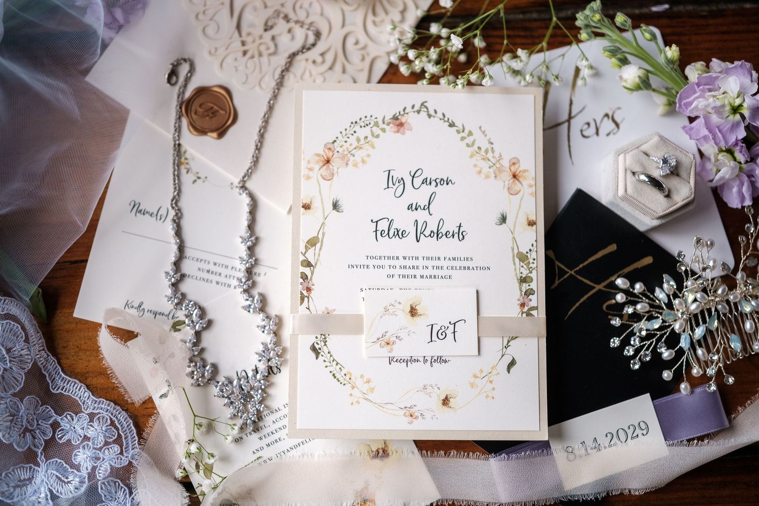 Elegant wedding invitations and stationery with floral designs and calligraphy displayed on a rustic wooden surface.