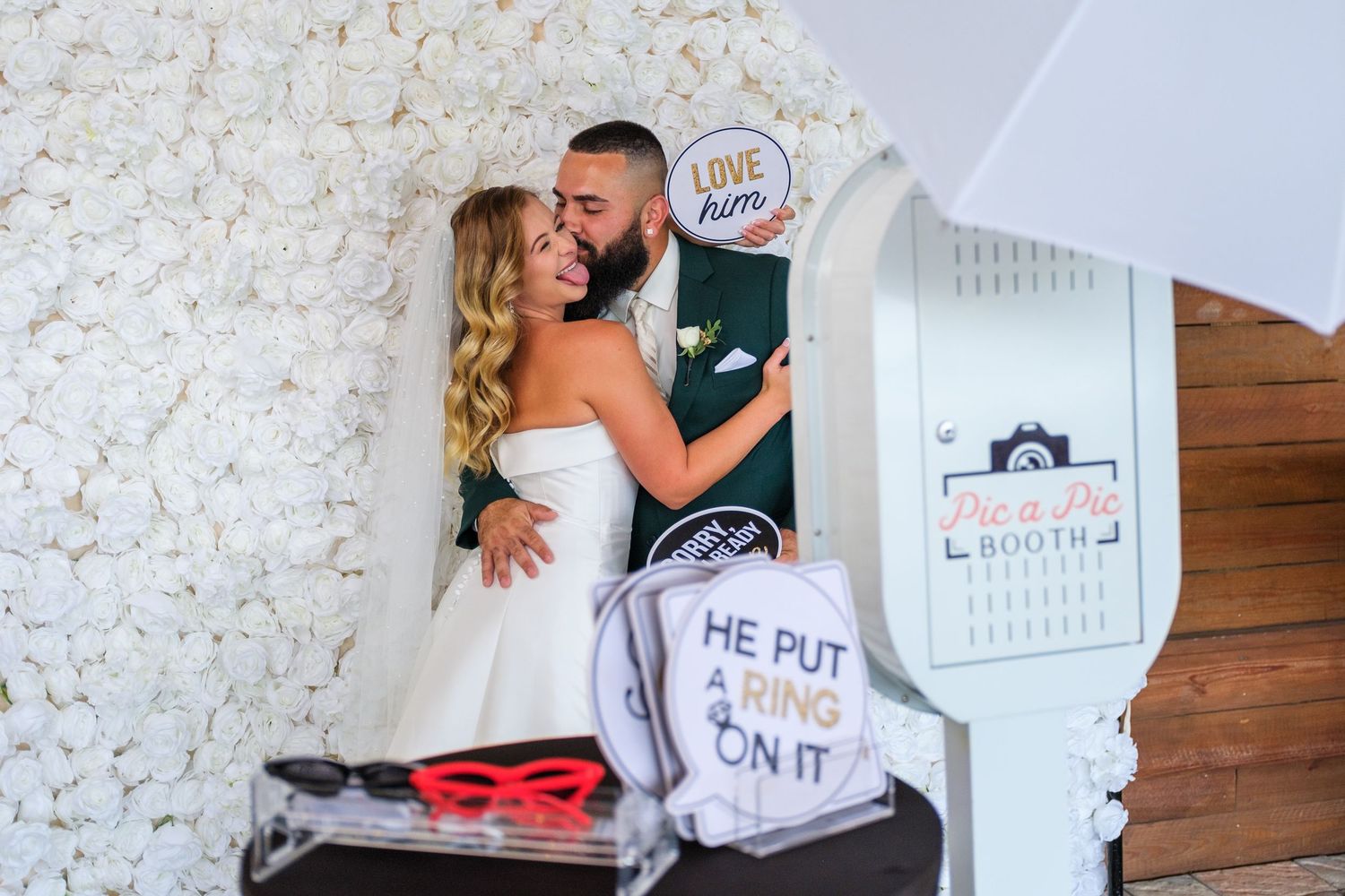 A series of romantic engagement photos showing a couple embracing and celebrating with props and signs.