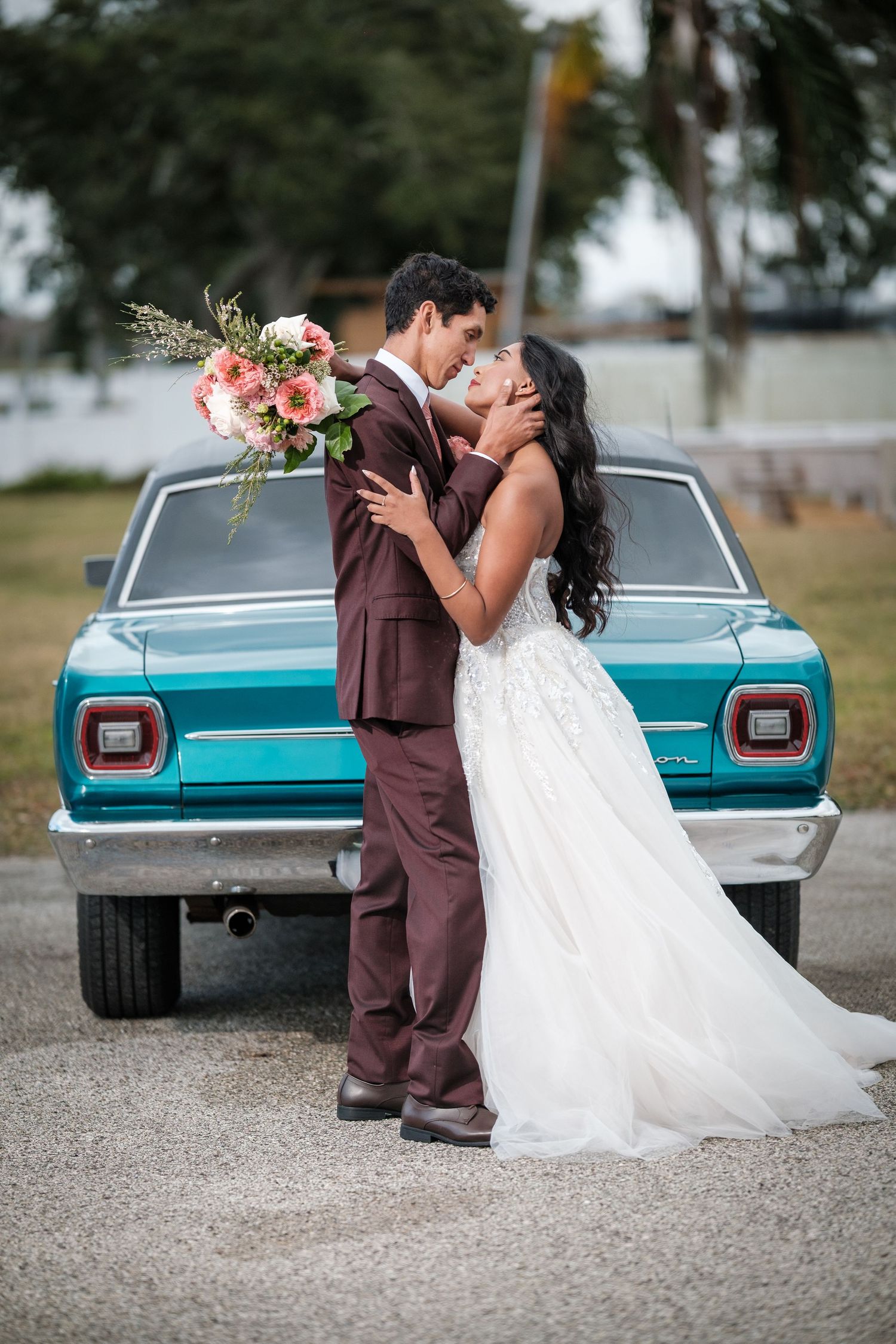 A romantic wedding couple poses with a vintage turquoise car, showcasing their special moment in a series of intimate shots.