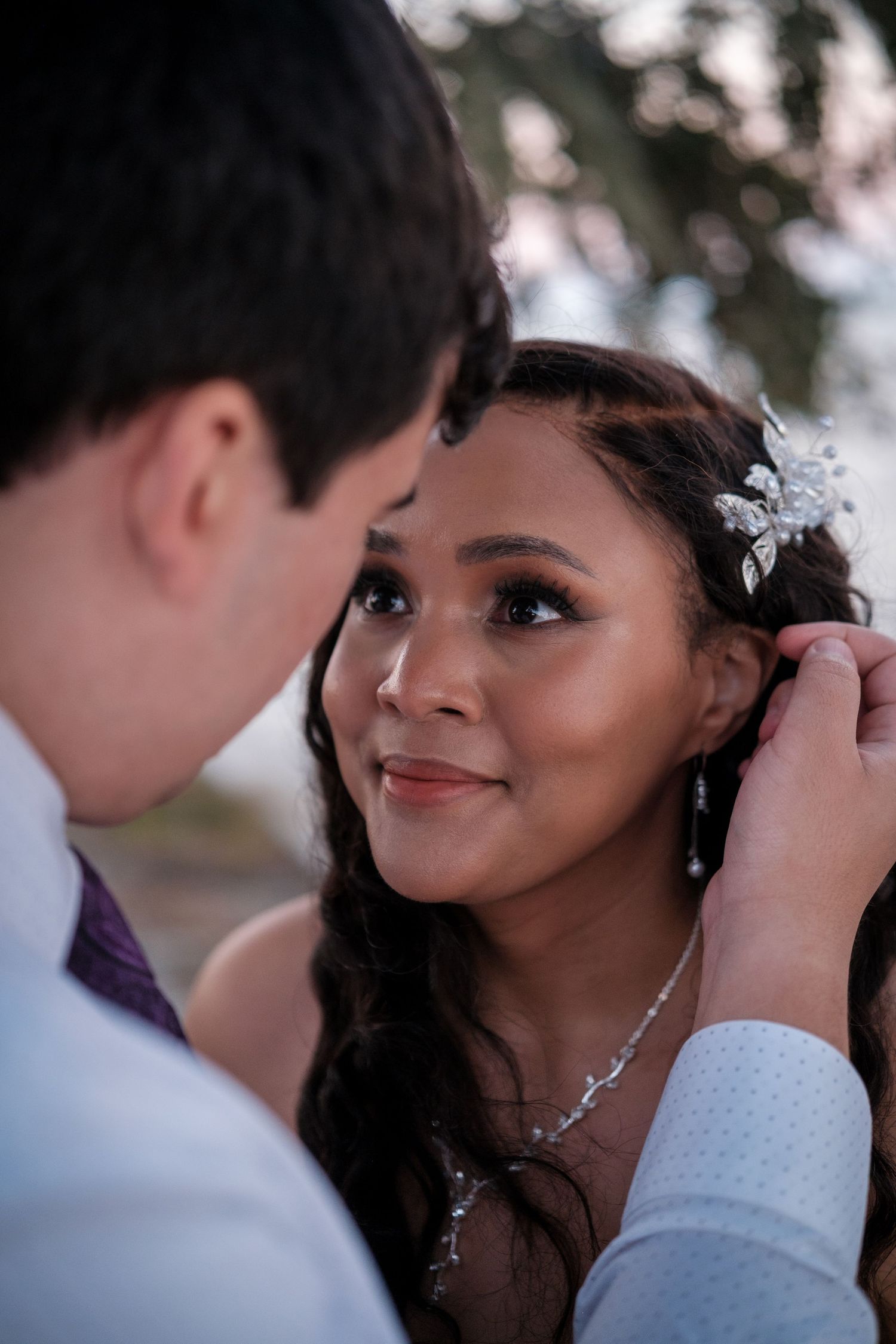 Romantic wedding moment captured as couple shares intimate glance during outdoor ceremony.