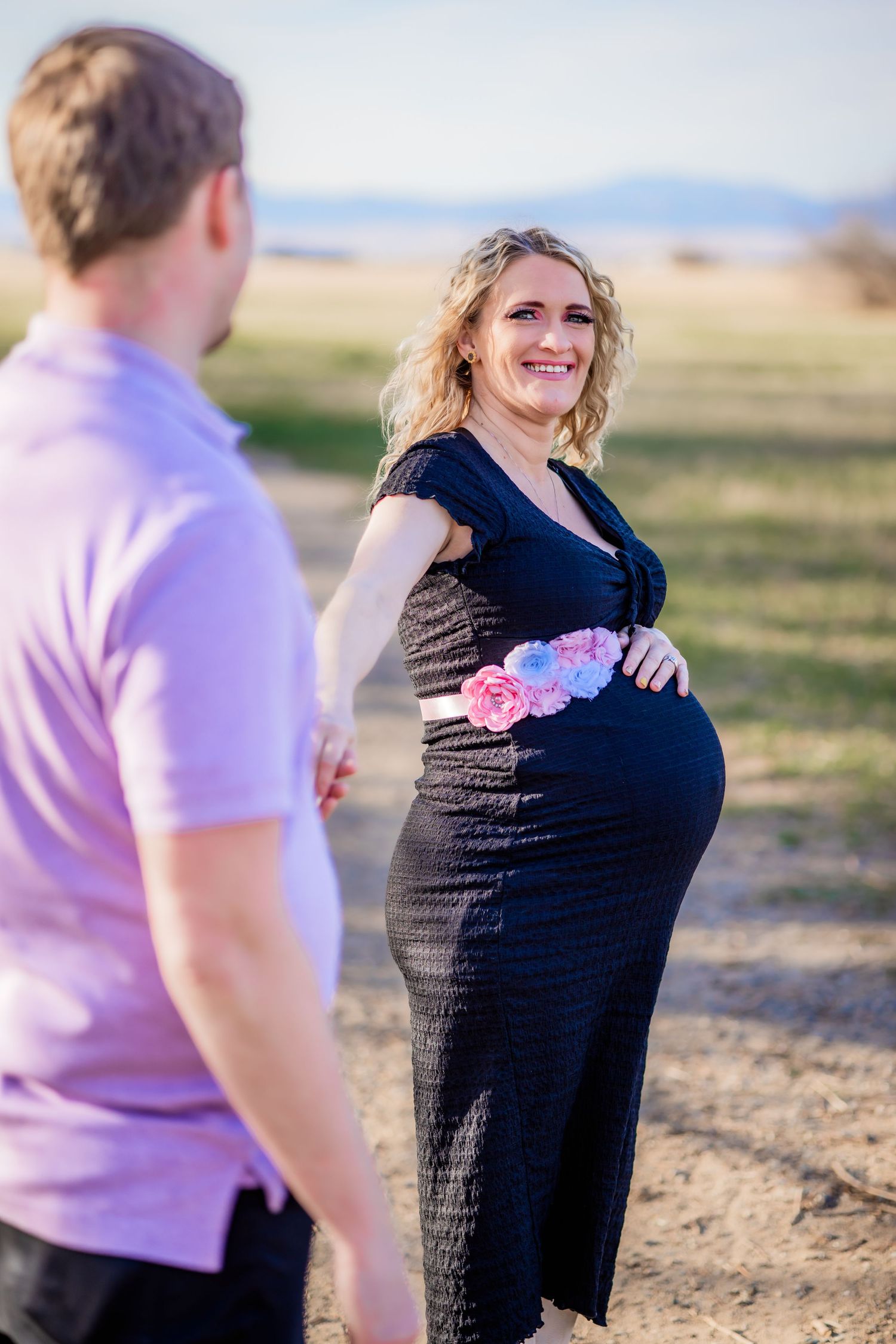 Expectant couple enjoying a romantic maternity photoshoot outdoors.