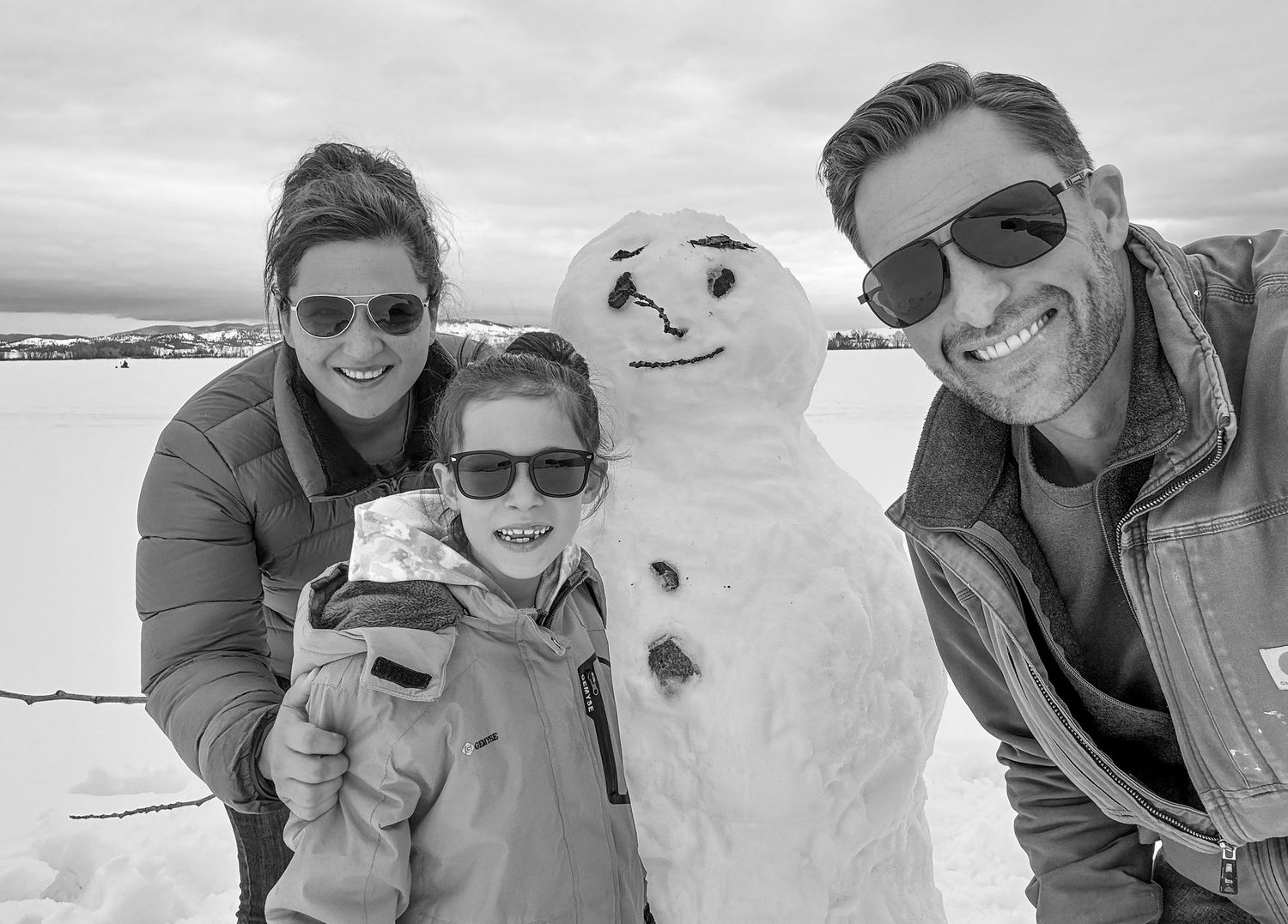Group photo with a snowman on a snowy winter day.