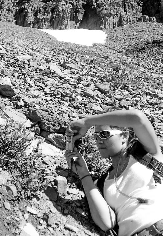 Person taking a break while hiking in rocky mountain terrain on a sunny day.