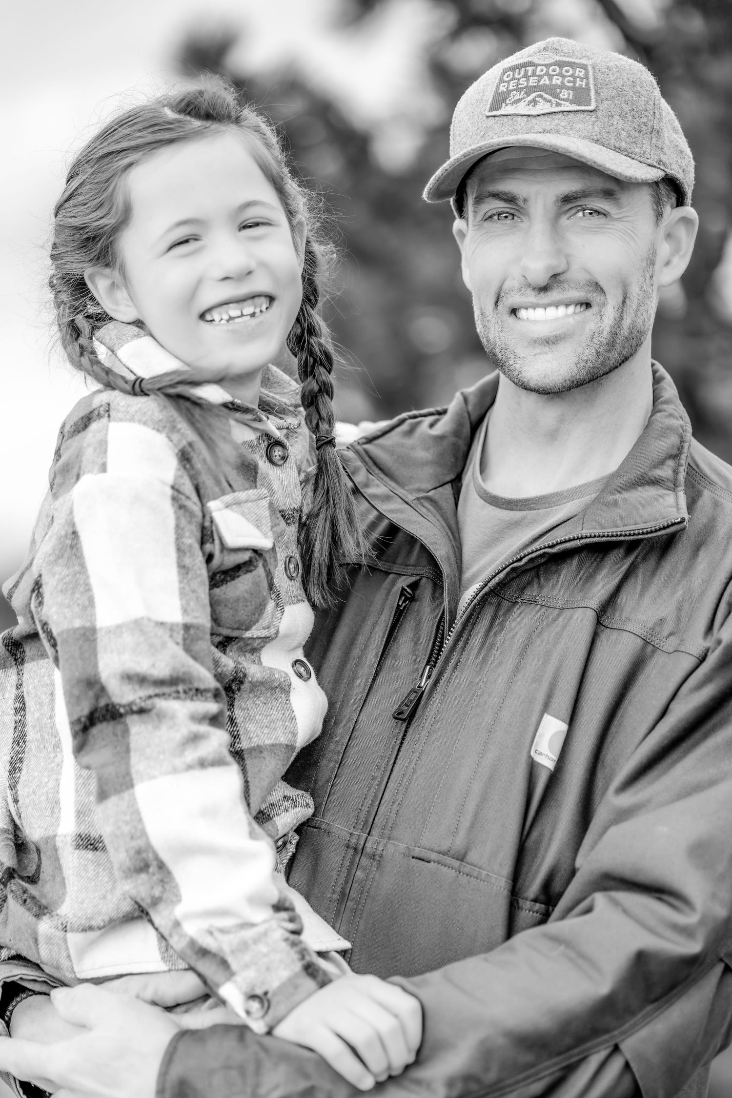 Black and white portrait of two people in outdoor winter clothing.
