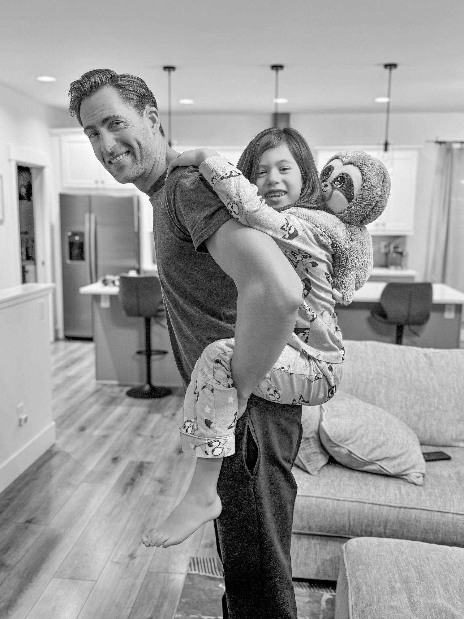 Playful moment captured in a modern living room with people and a stuffed animal.