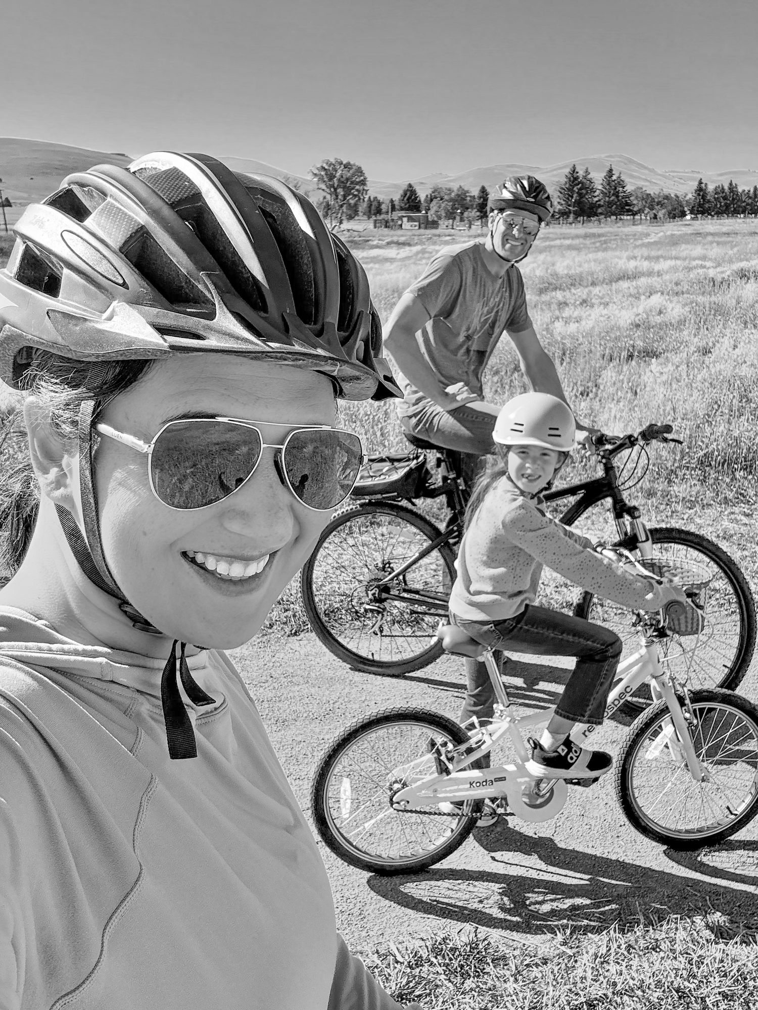 Family biking adventure on a scenic trail with mountains in the background.