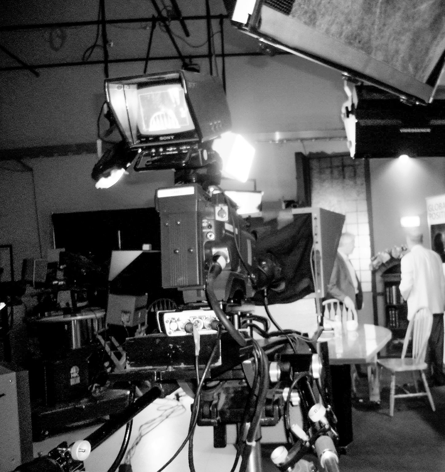 Professional television camera equipment set up in a dimly lit studio.