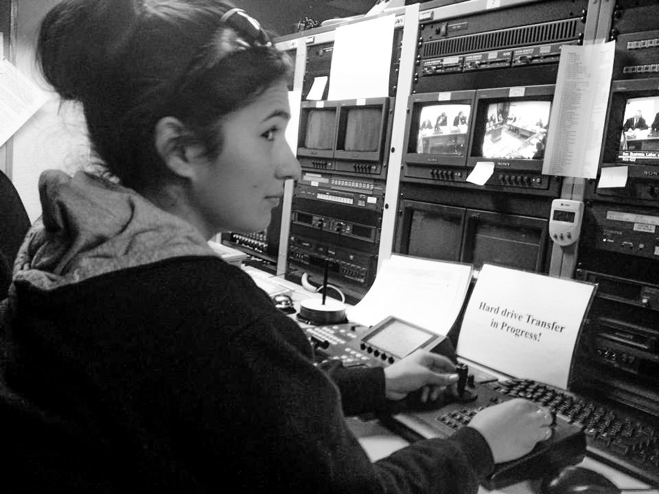 Person working at a professional broadcasting control panel in black and white.