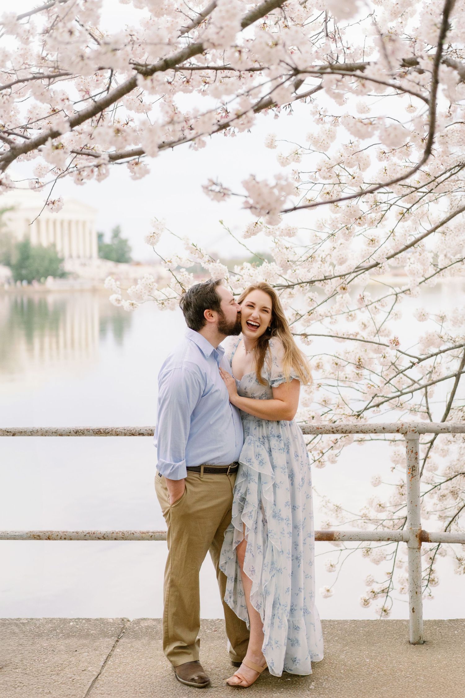 A joyful moment captured between a couple during cherry blossom season.