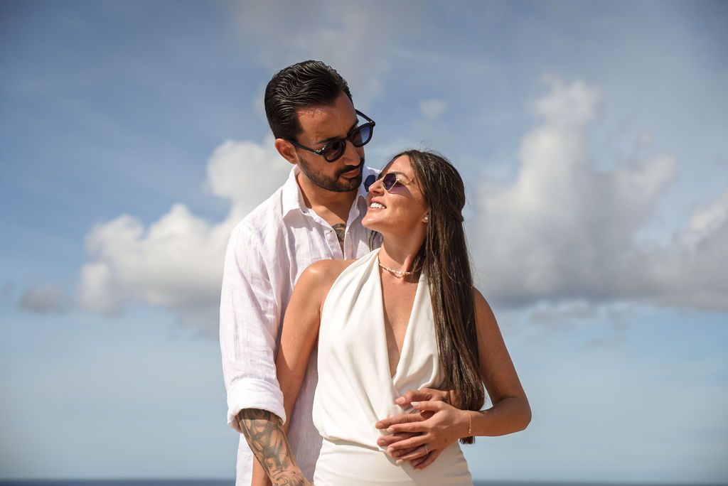 Couple portrait after proposal with romantic clouds in the background