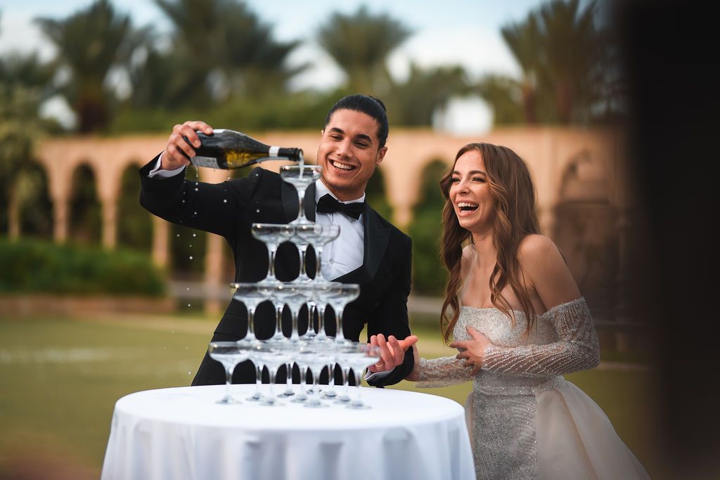 Bride and groom with a Champagne tower at a wedding at Palais Namaskar in Marrakesh.