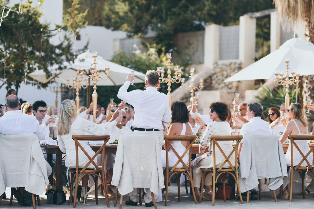 Wedding guests tost at the table during a private villa wedding in Ibiza.