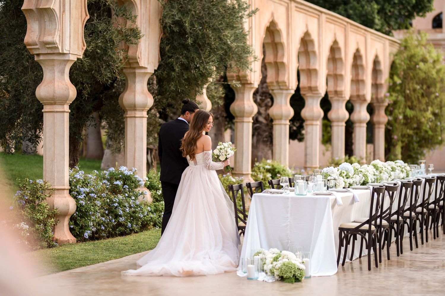 Bride and groom seeing their wedding table setup for the first time at Palais Namaskar in Marrakech, surrounded by candles and elegant decor