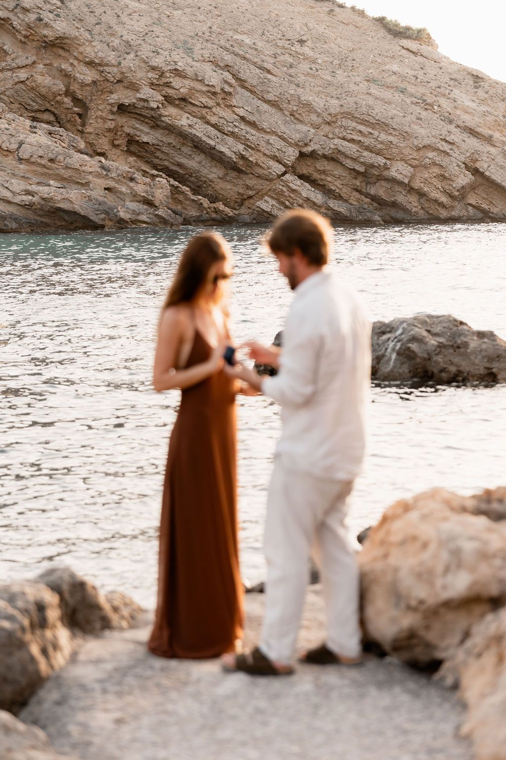 An intimate engagement moment during a surprise proposal at Cala Molí, Ibiza.