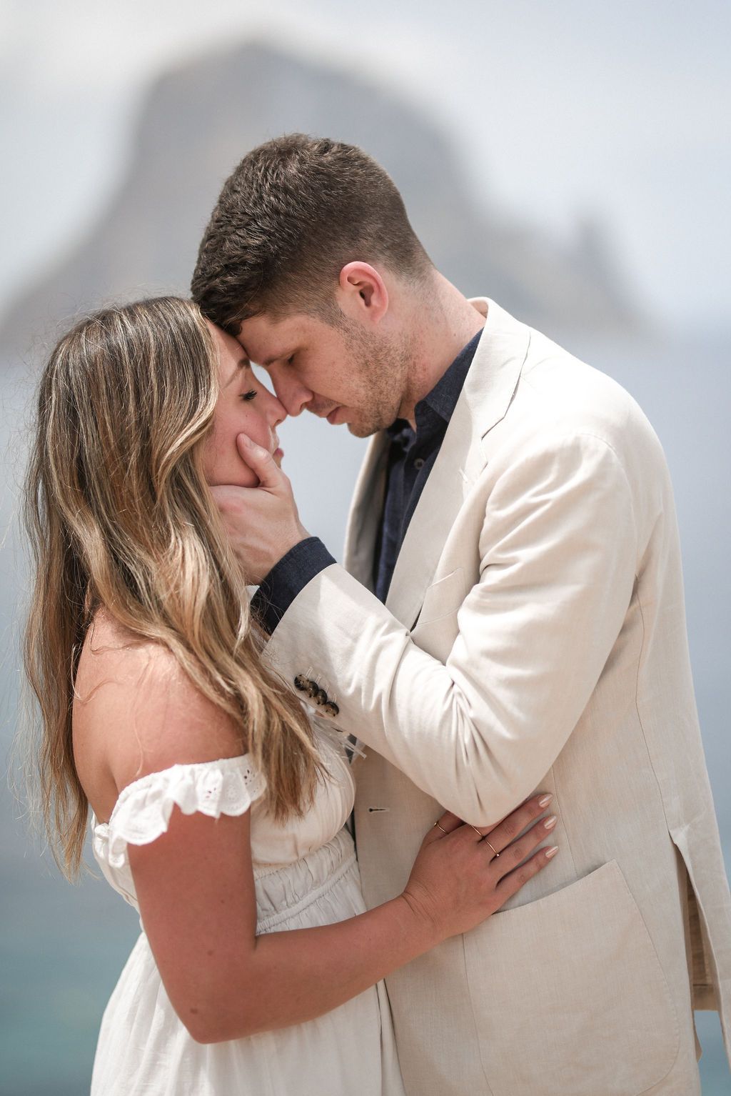 Engaged couple photographed in Ibiza during a romantic engagement session with Es Vedra in the back.