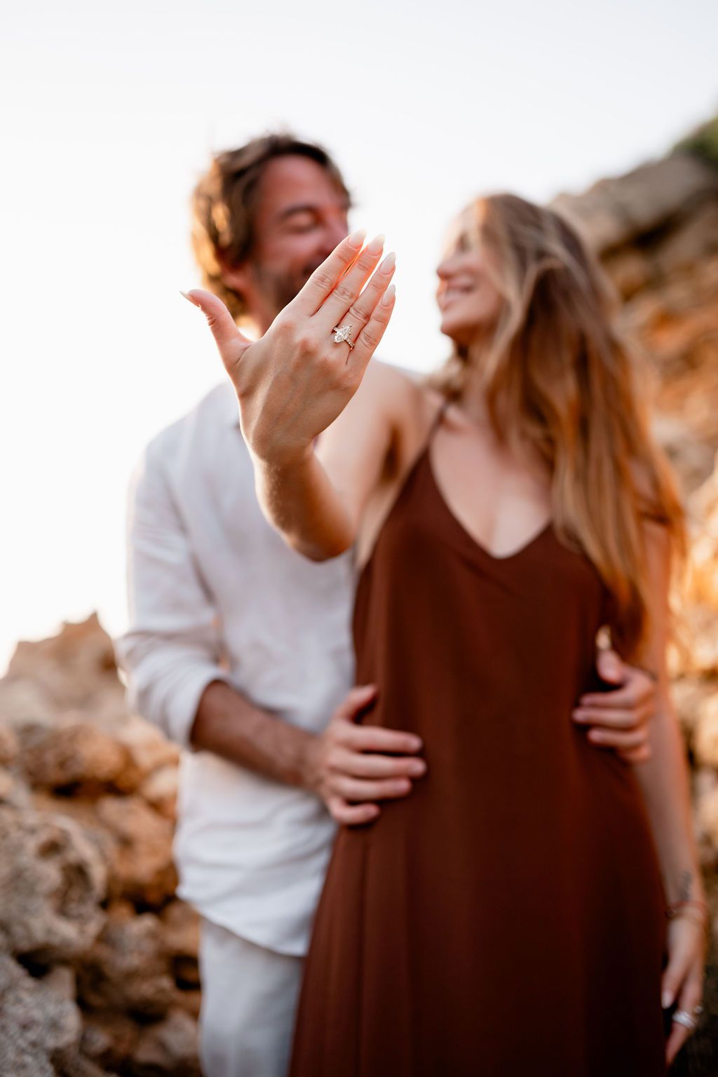 Natural engagement portraits of a couple after their surprise proposal at Cala Molí.
