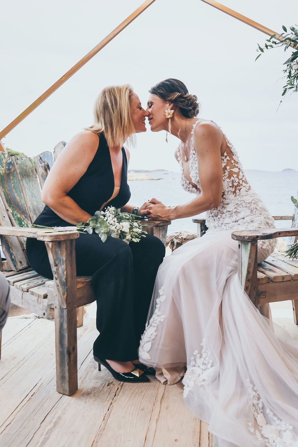 Bride and bride sharing a kiss at their wedding at Babylon Beach Ibiza.