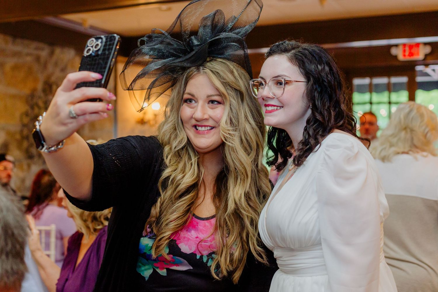 A group of people celebrate and dance together at an indoor party venue.