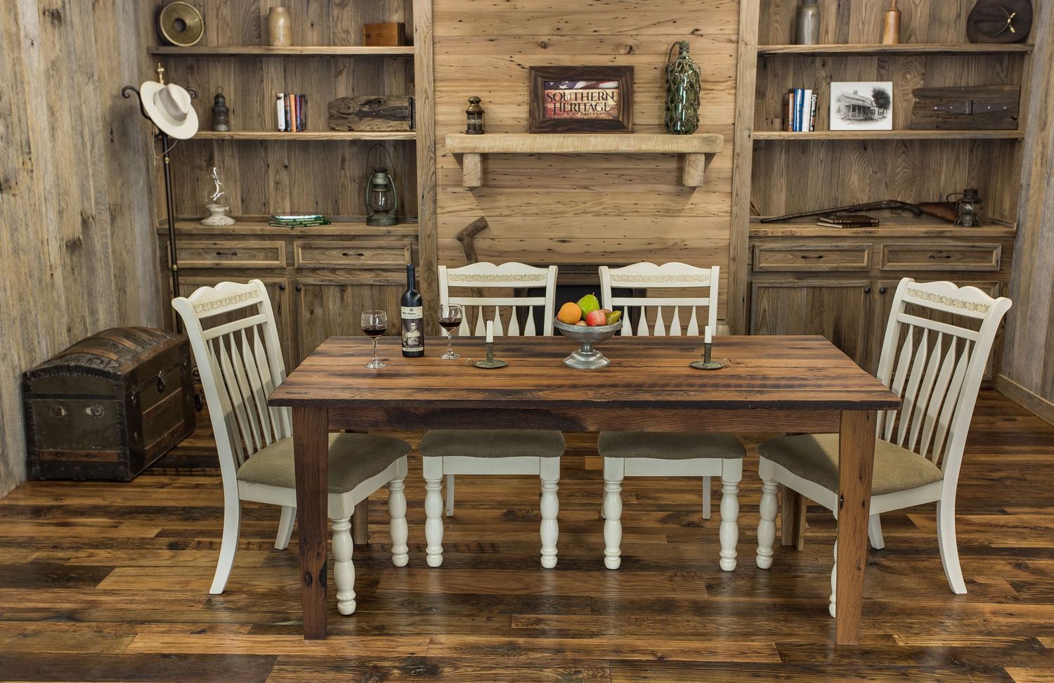 Rustic farmhouse dining set with distressed wood table and four white chairs in a cozy wooden cabin interior.