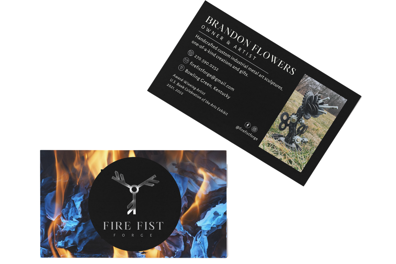 Two business cards for Fire Fist Forge and Brandon Flowers metal artist, featuring fire background and blacksmith artwork.