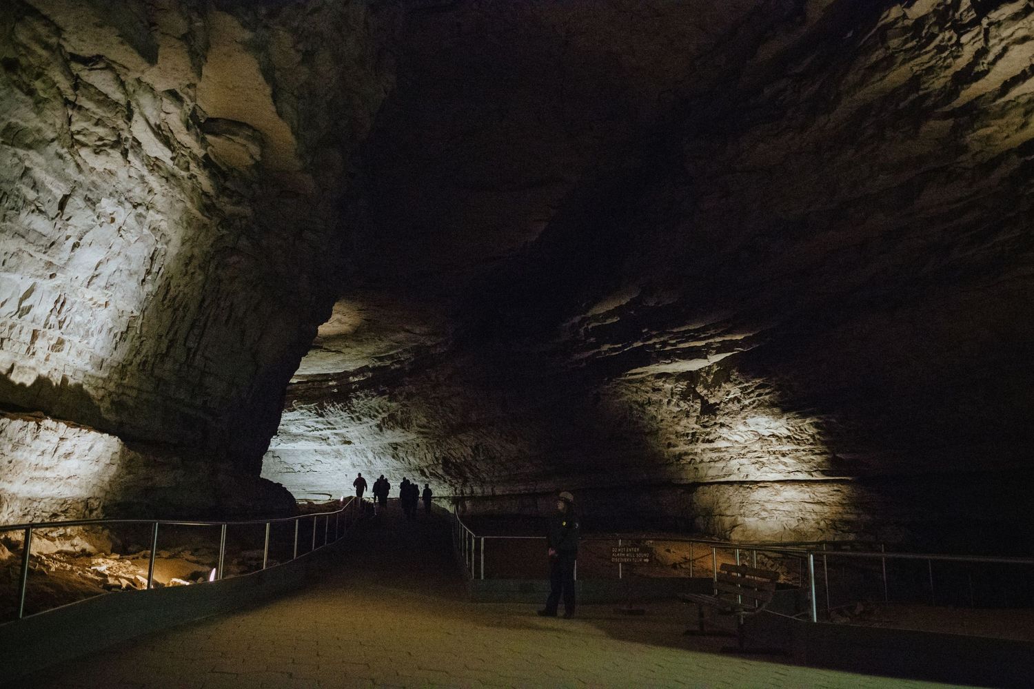 Visitors explore the vast illuminated chambers of Mammoth Cave, showcasing stunning limestone formations and pathways.