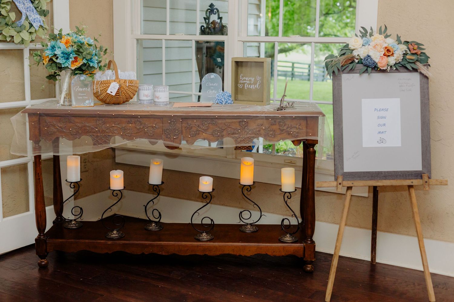 Elegant wedding venue display with rustic wooden tables, floral arrangements, and vintage decor elements.