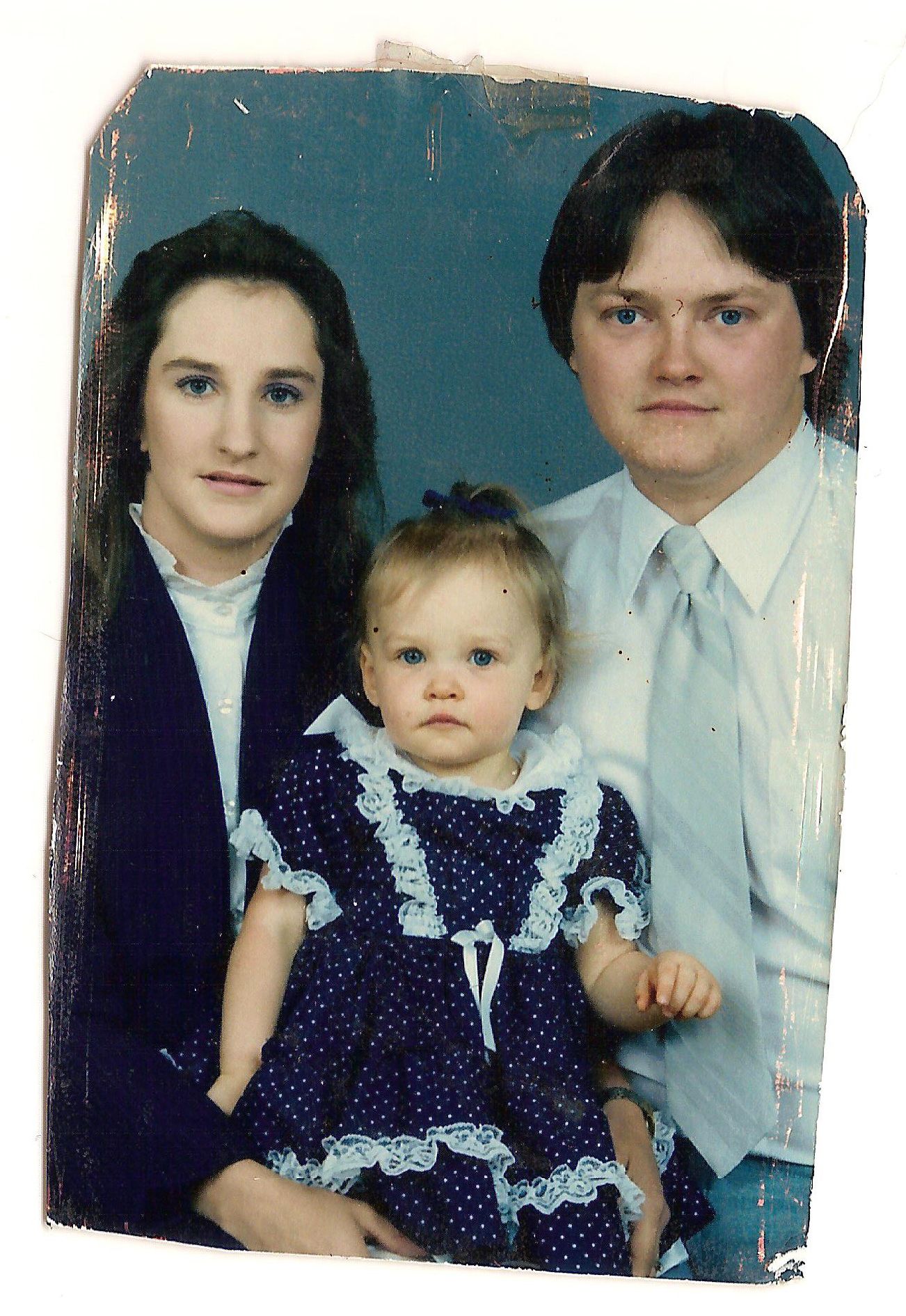 A faded sequence of vintage photographs showing a parent and young child in matching blue polka dot outfits.