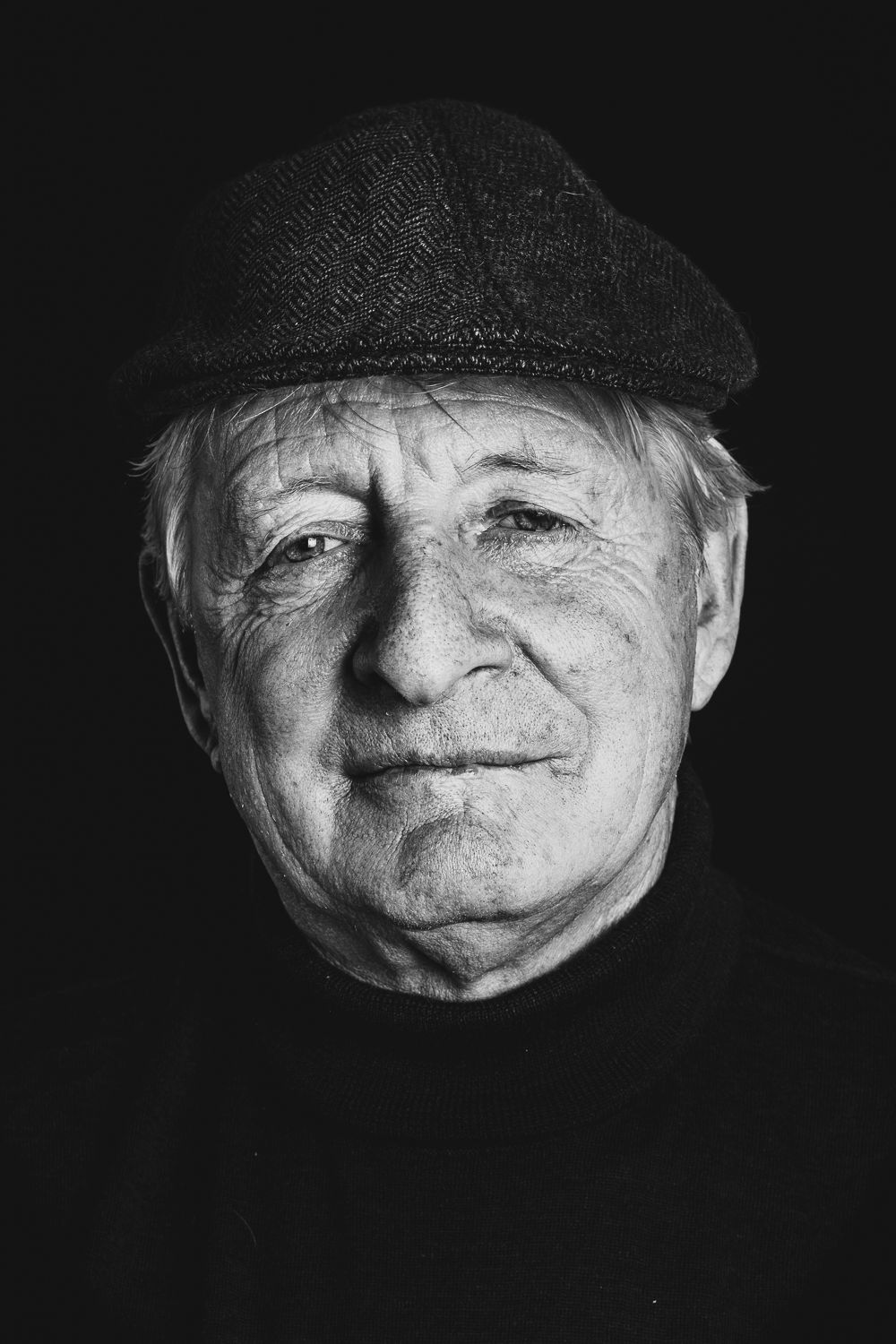 Black and white portrait series showing close-up facial expressions of a person wearing a cap against dark background.